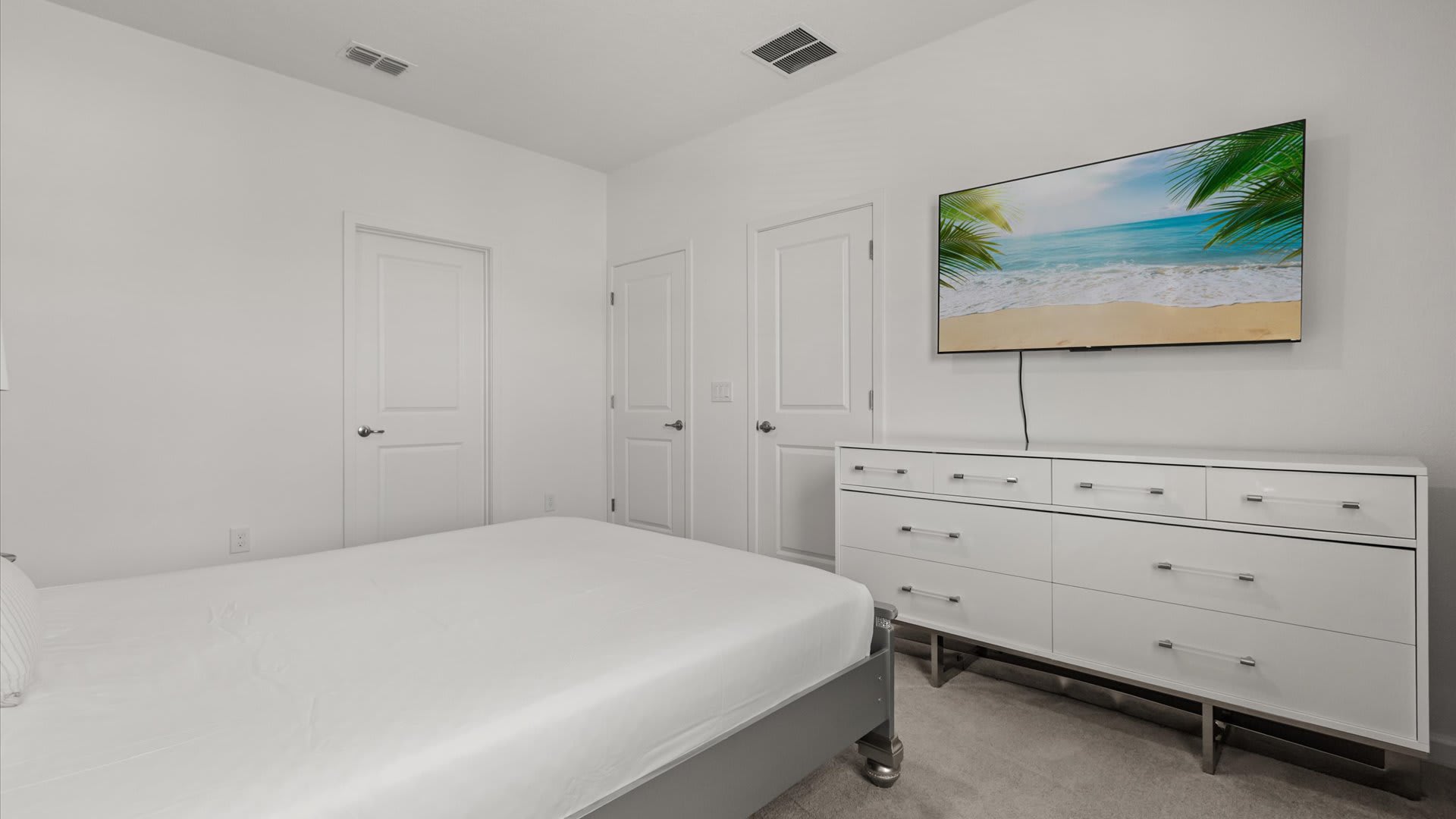 Bedroom 3: Cozy and inviting space with a Queen bed, a smart TV, an ensuite bathroom, and soft modern tones for restful nights.