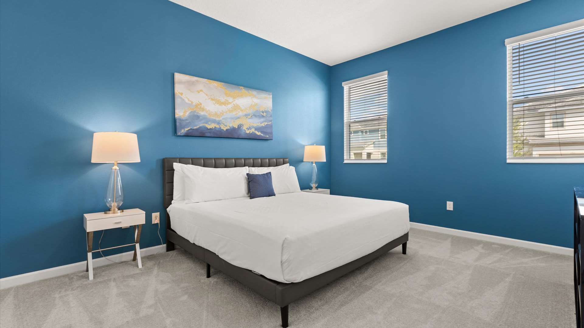 Bedroom 2 – Queen Suite: Spacious and cheerful with a bold blue feature wall, this queen suite offers comfort and relaxation for parents or couples.