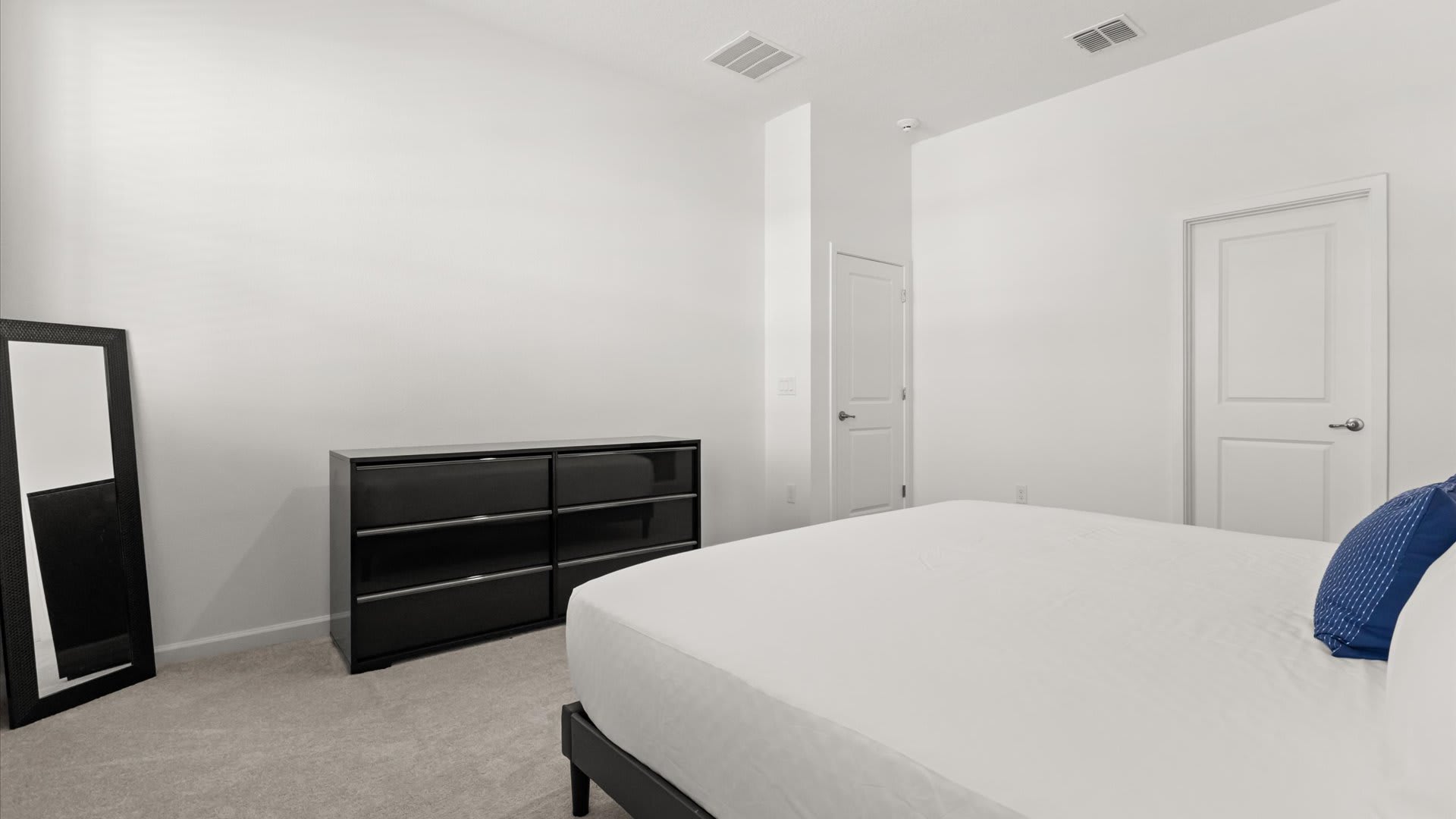 Bedroom 2 – Queen Suite: Spacious and cheerful with a bold blue feature wall, this queen suite offers comfort and relaxation for parents or couples.