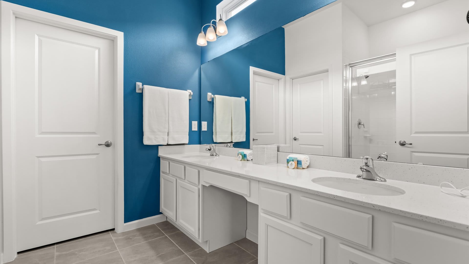 Bright and spacious en-suite bathroom with a large standing shower and dual basins.