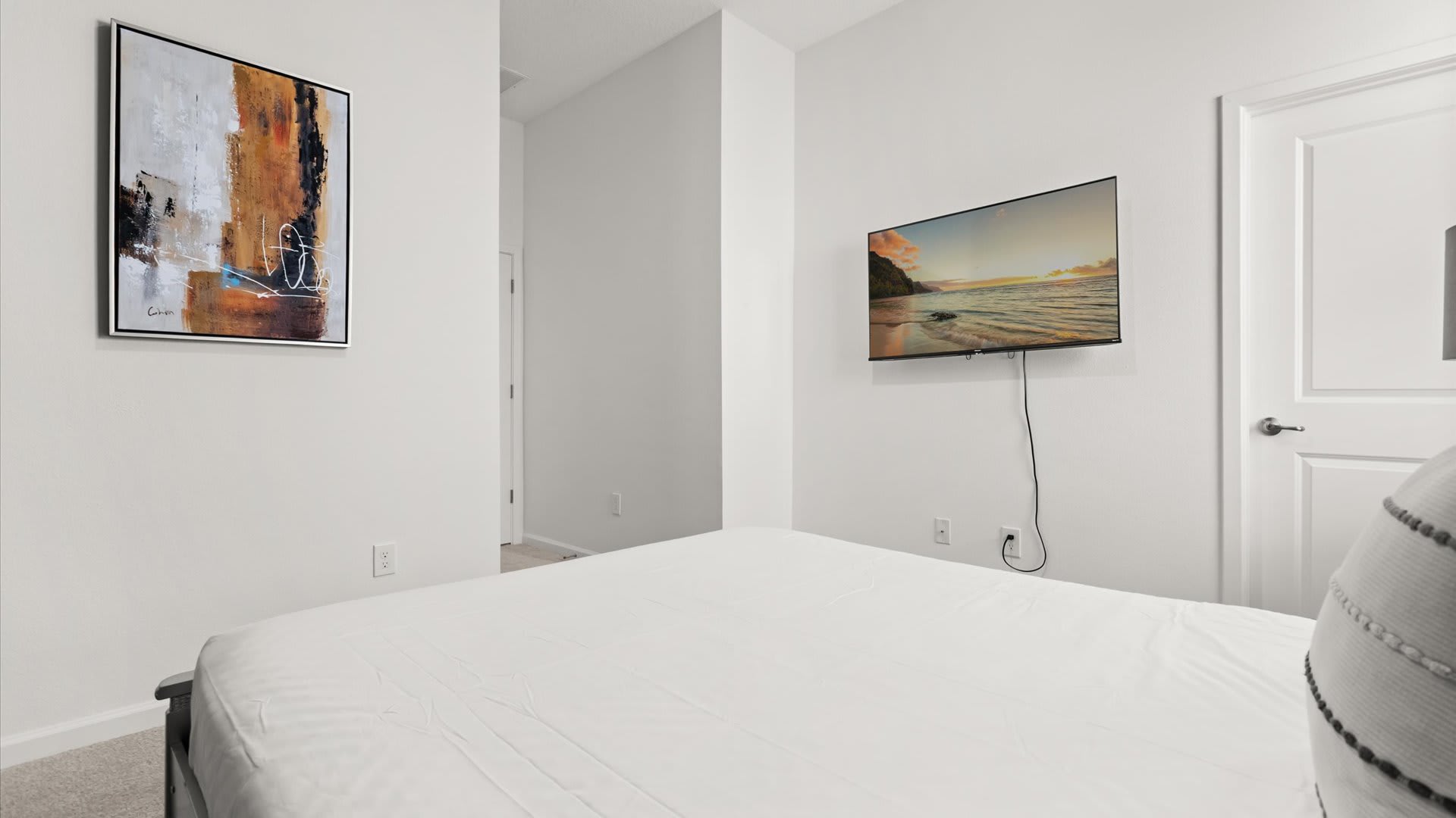 Bedroom 7: Queen Bedroom with a smart TV and warm golden tones.