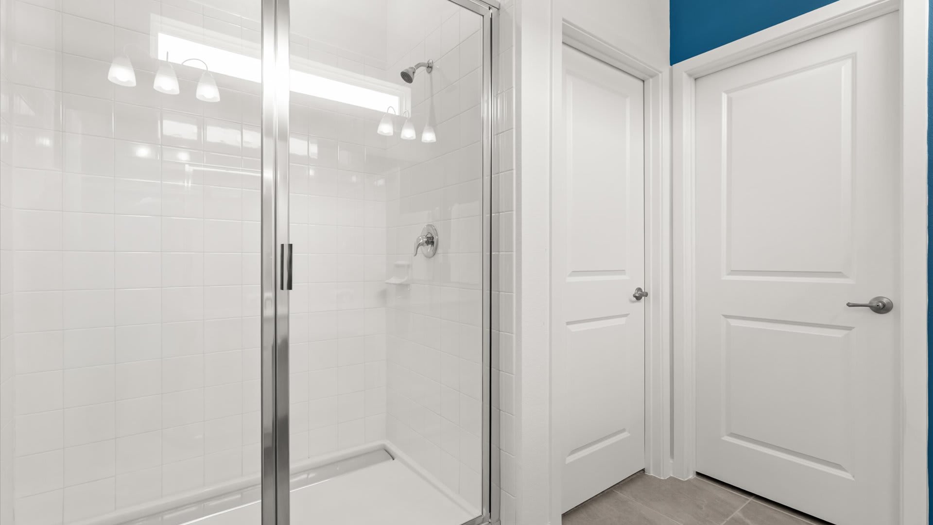 Bright and spacious en-suite bathroom with a large standing shower and dual basins.