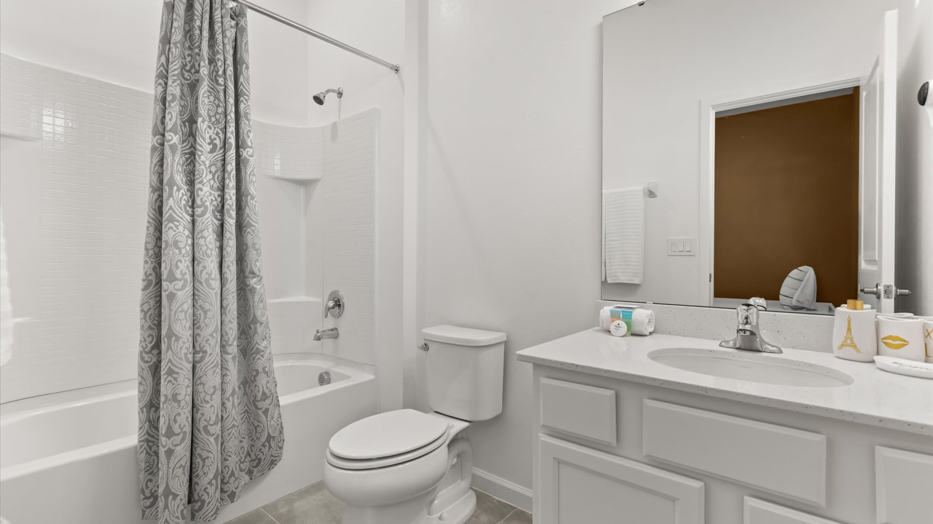 Clean and simple bathroom with combined bathtub and shower.
