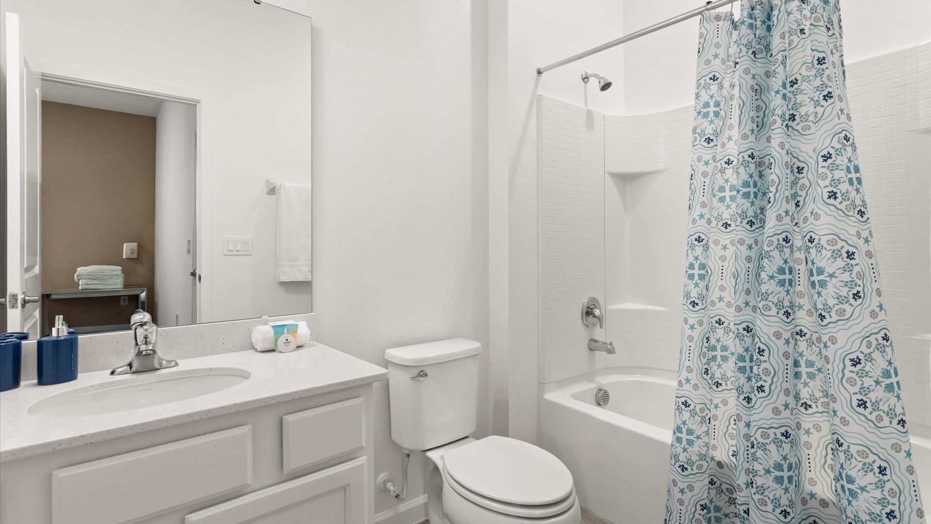 Charming bathroom with a shower/bathtub combo and a neat vanity.