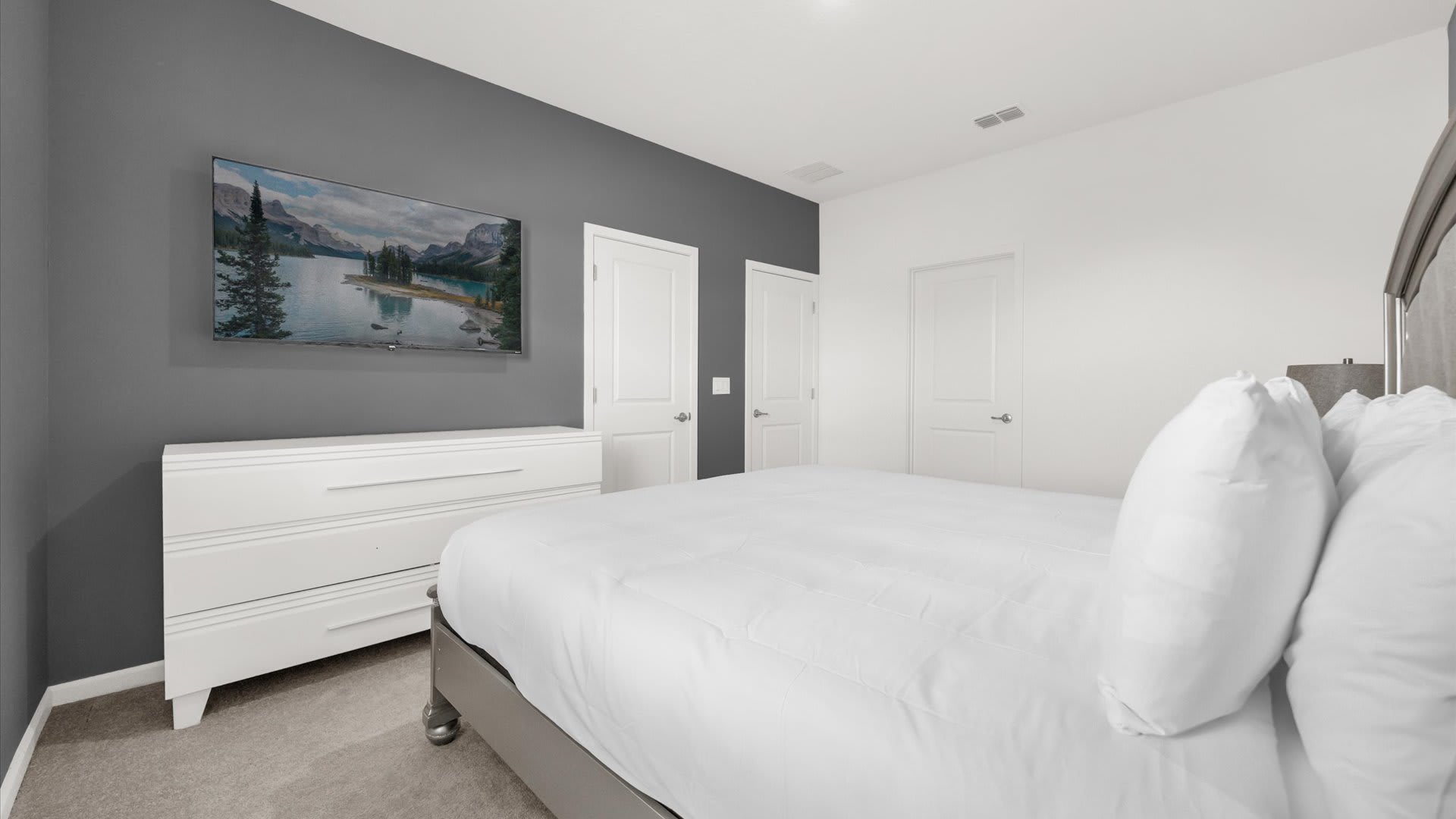 Bedroom 1 – King Suite – Stylish king bed, ensuite bathroom with smart TV.