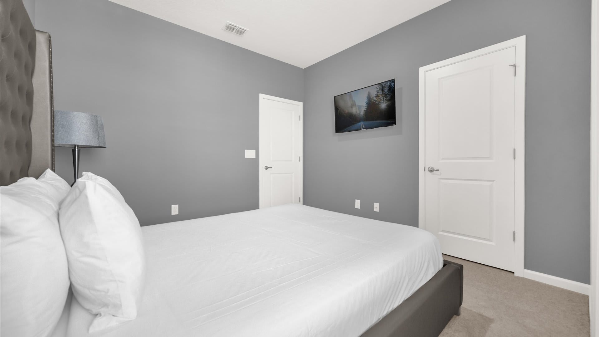 Bedroom 2 – Queen Suite – Elegant décor and ensuite bath with smart TV and en-suite bathroom.