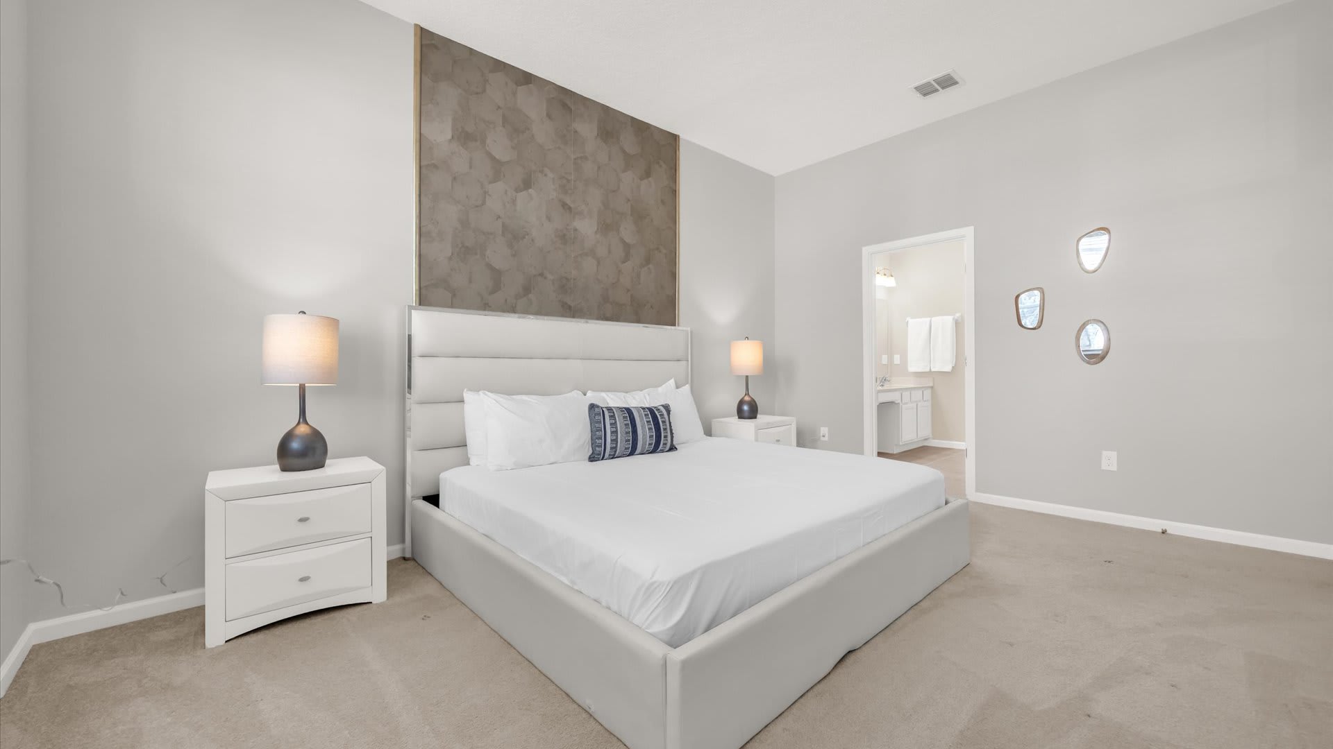 King Suite – Stunning bedroom space with light walls, a smart TV, and an ensuite bath.