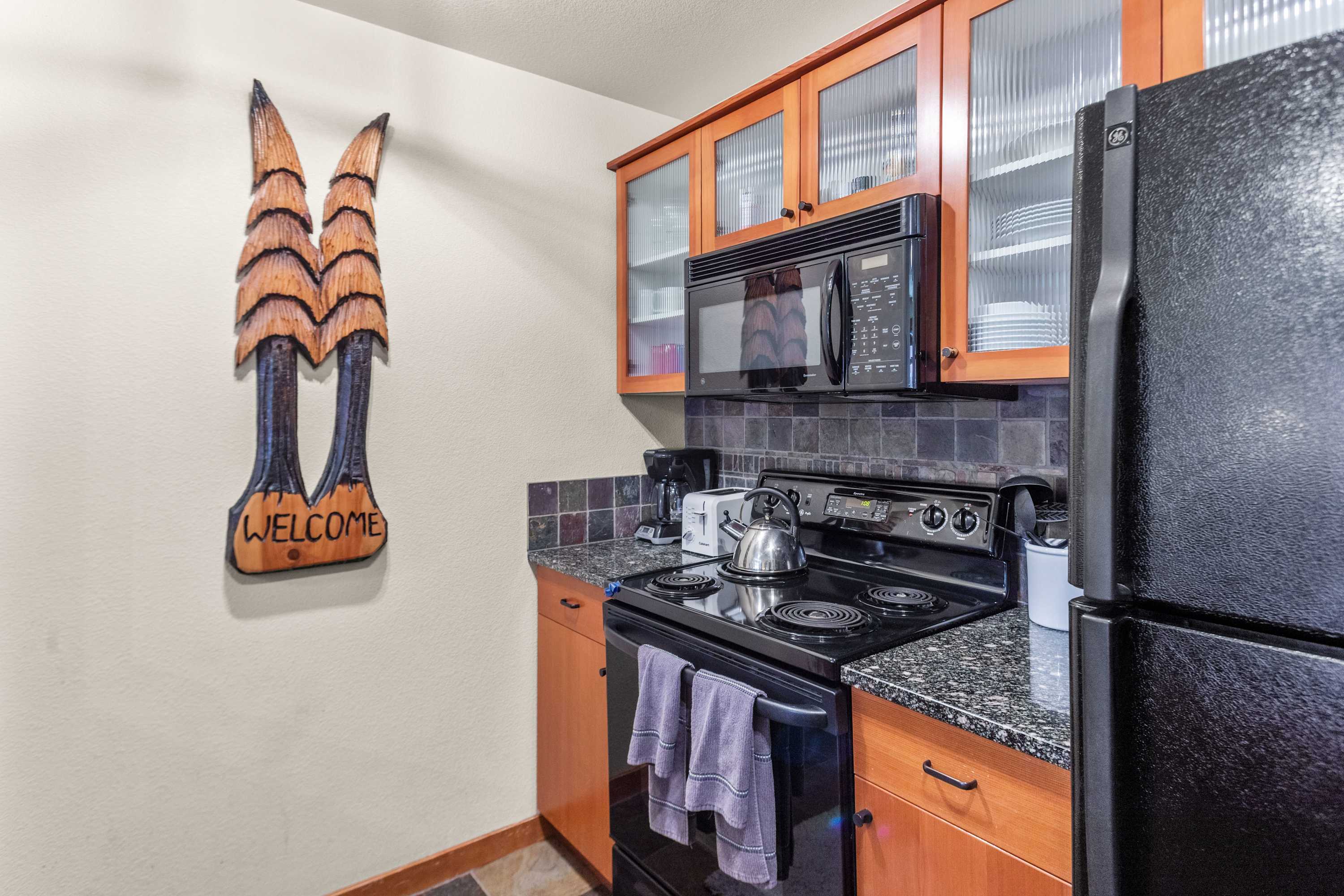 Fully equipped kitchen, tiled backsplash, fridge, stove, and dishwasher.