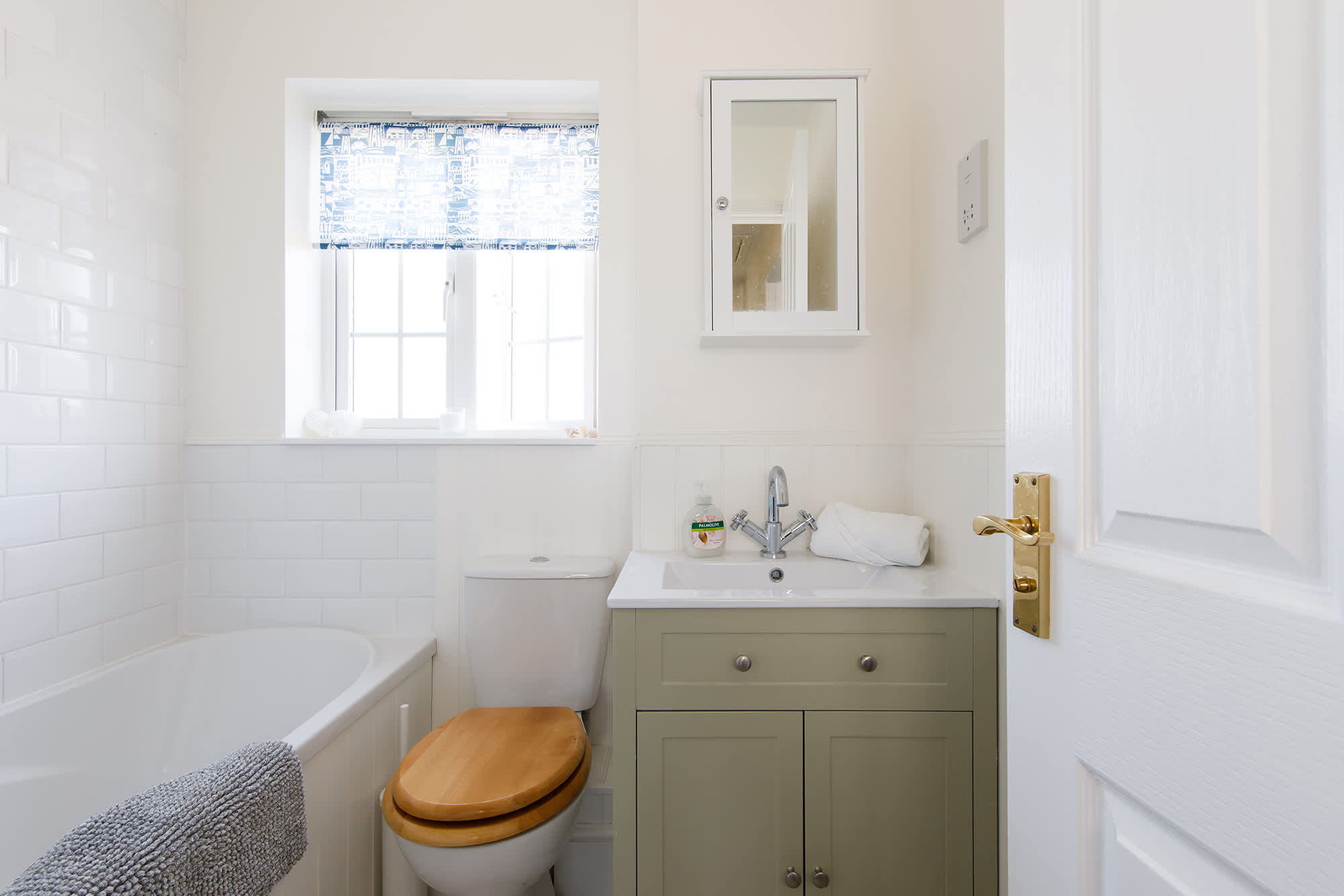 The family bathroom has a bath with overhead shower, WC and sink.
