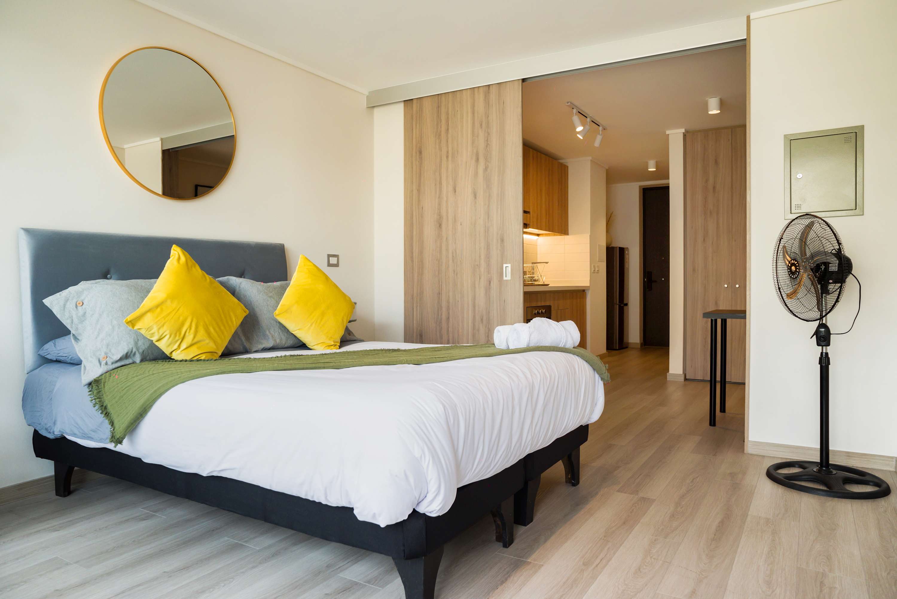 Relax in this chic studio with vibrant decor, a cozy bed, and a functional kitchenette, perfect for a tranquil city escape.