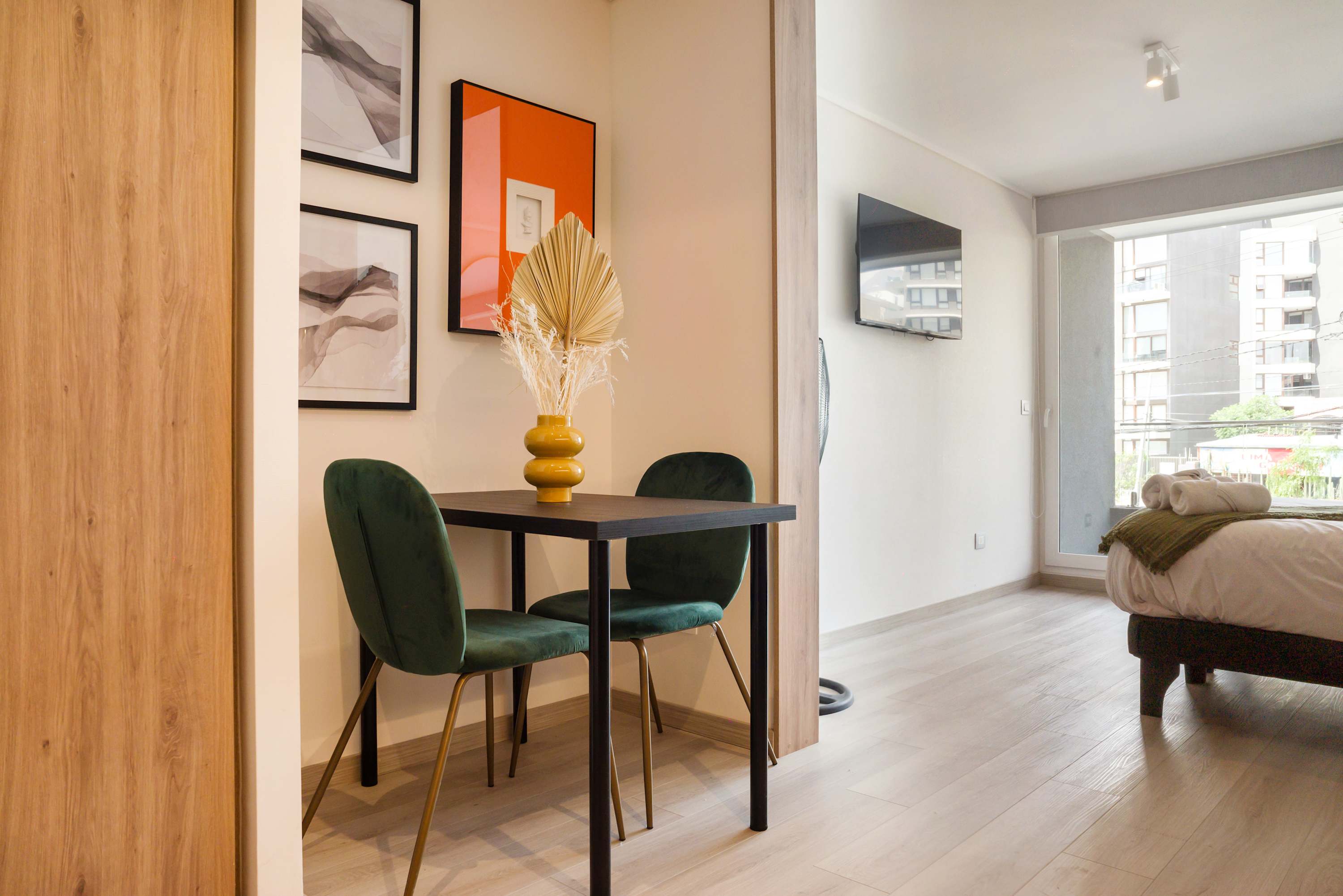 Chic dining nook with modern decor and ample natural light, perfect for intimate meals in a stylish studio.