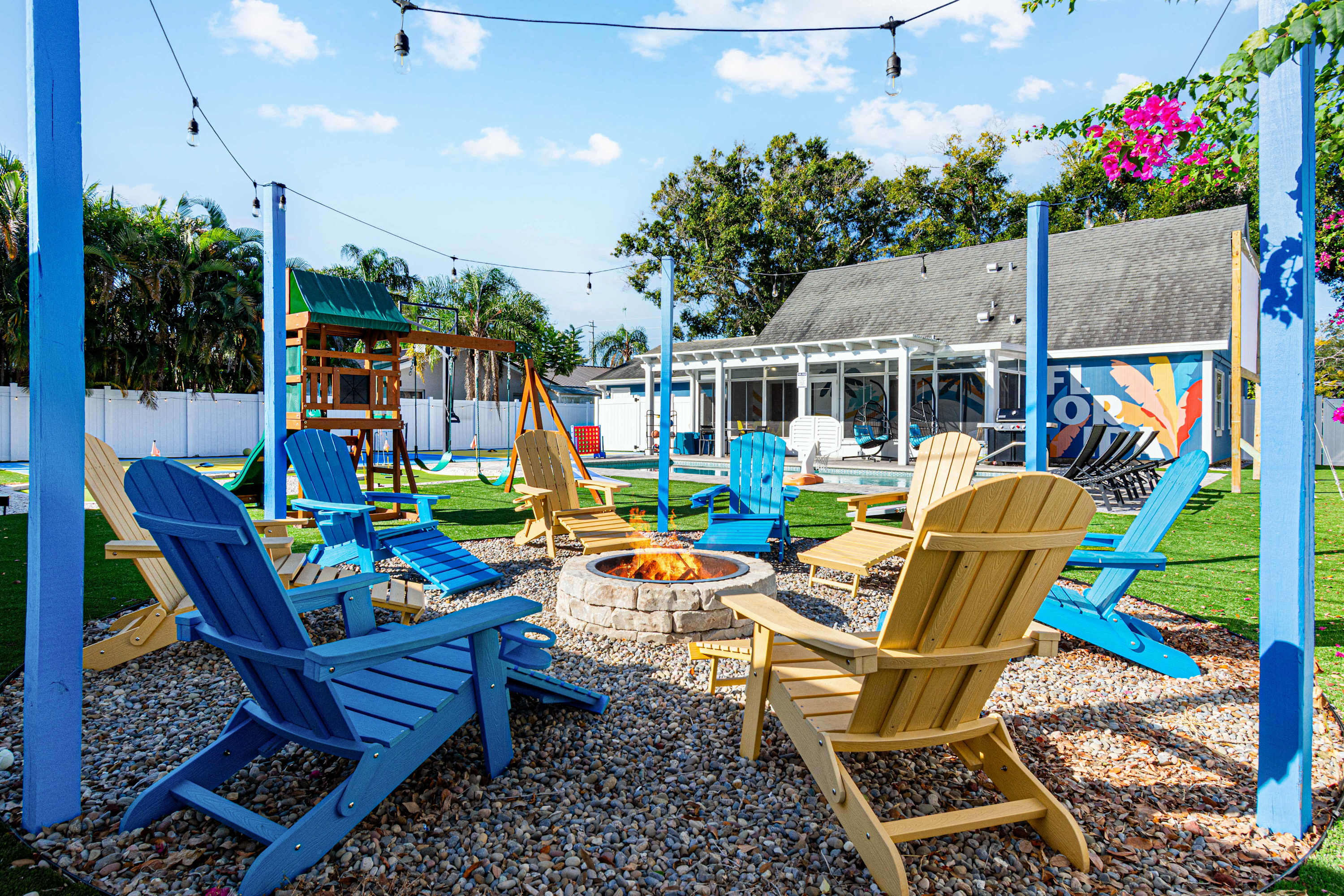 Backyard firepit with kids playset during the day