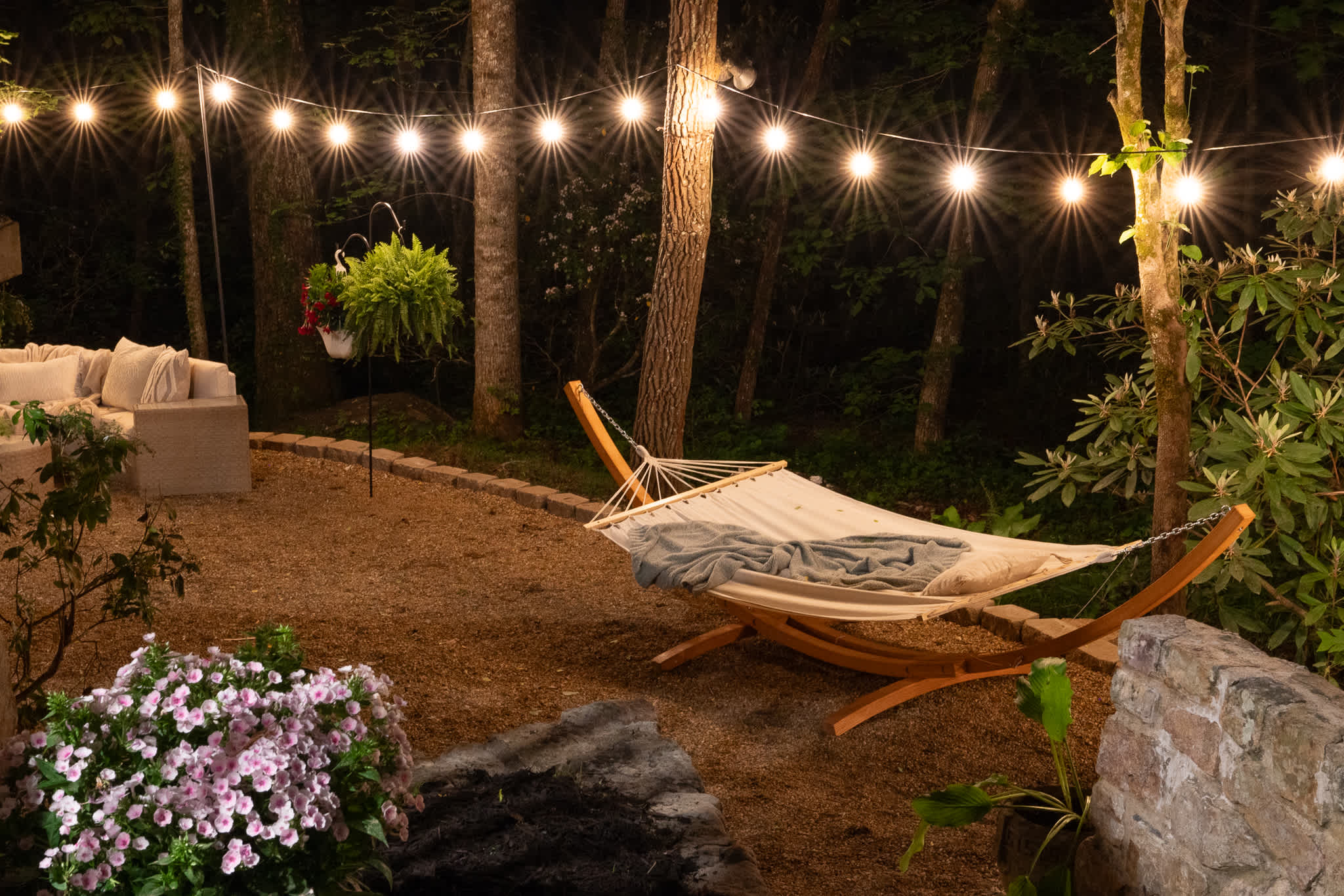 Swing into relaxation beneath twinkling lights and forest vibes