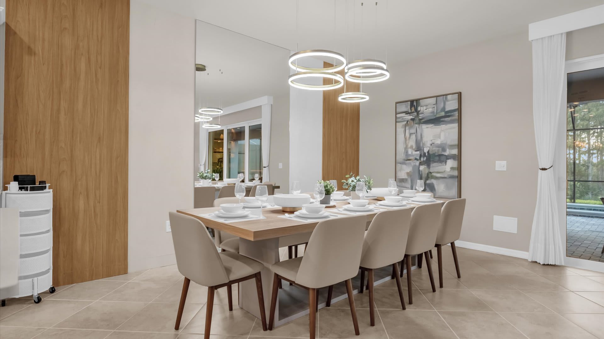 Elegant dining area with seating for 10 guests, a modern chandelier, and open access to the living space.