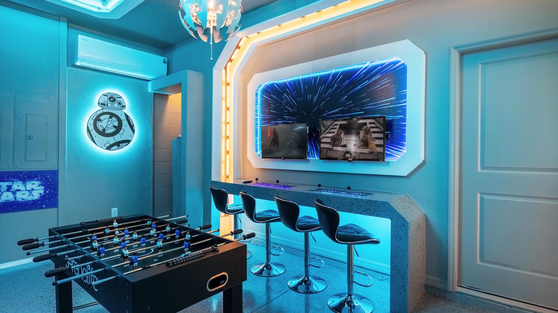 Futuristic arcade and foosball room with glowing blue décor and family-friendly entertainment.