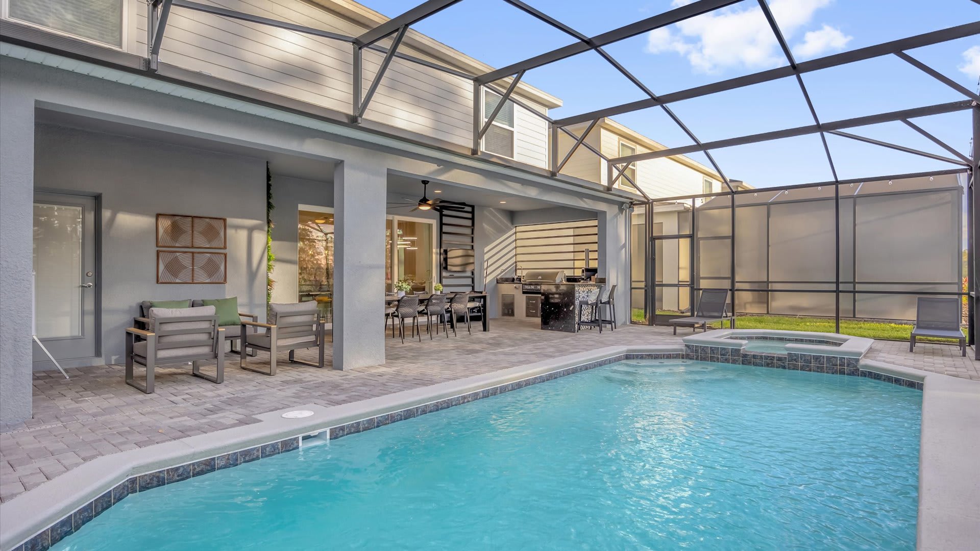 Private screened-in pool area with loungers and shaded dining space — perfect for relaxing days in the Florida sun.
