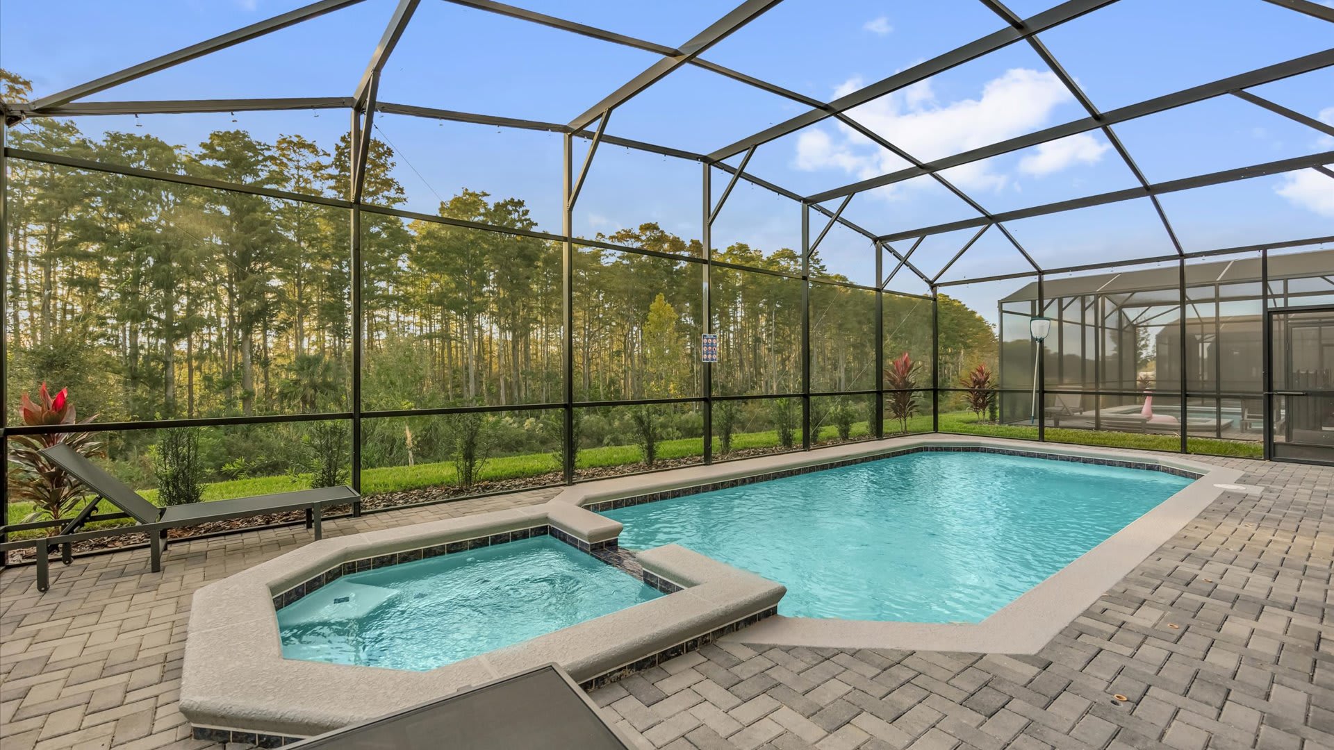 Private screened-in pool area with loungers and shaded dining space — perfect for relaxing days in the Florida sun.