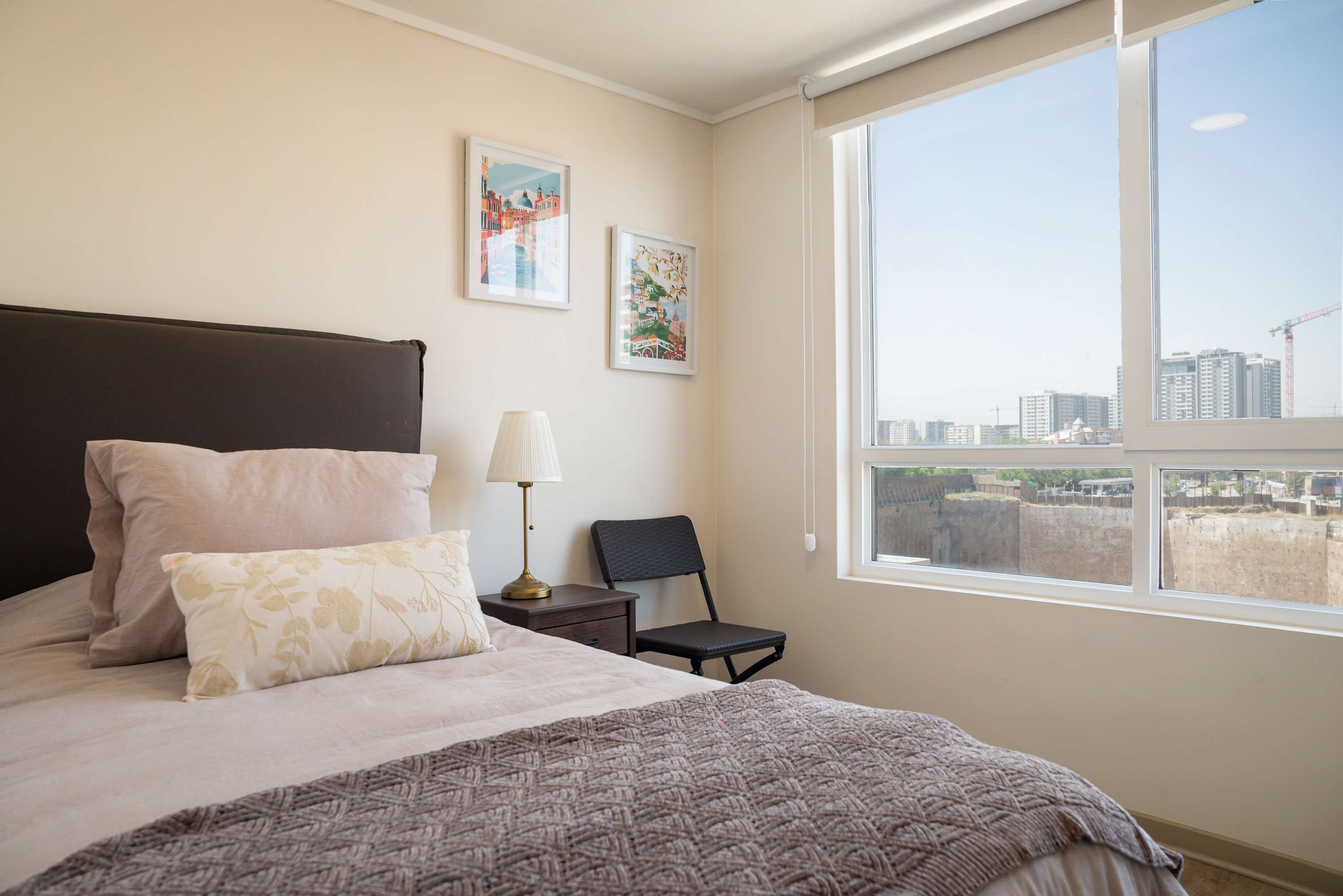 Bright and cozy bedroom with city views, perfect for a relaxing stay in the heart of Chile.