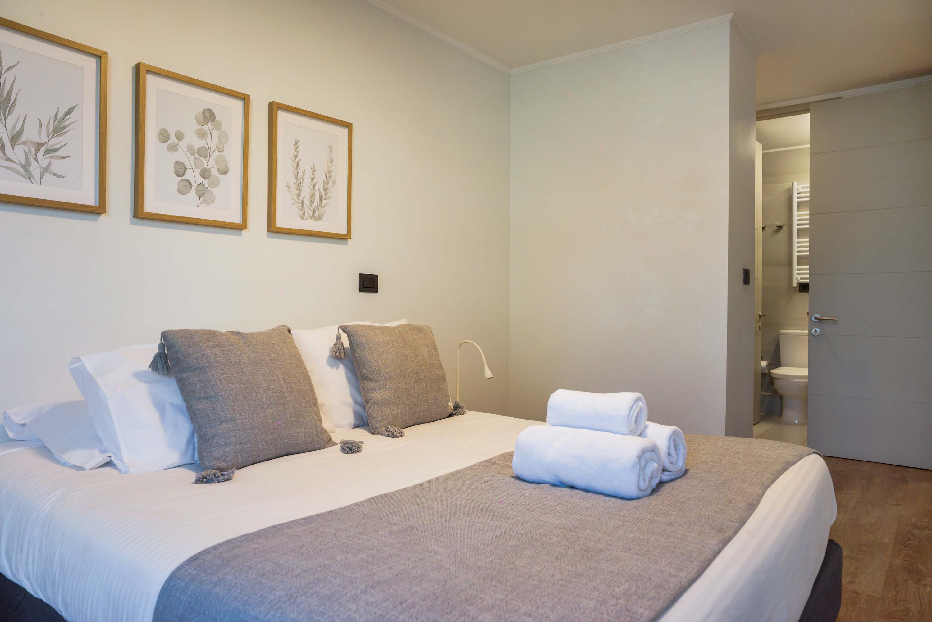 Unwind in this serene bedroom with elegant decor and convenient en-suite access, perfect for a relaxing stay.