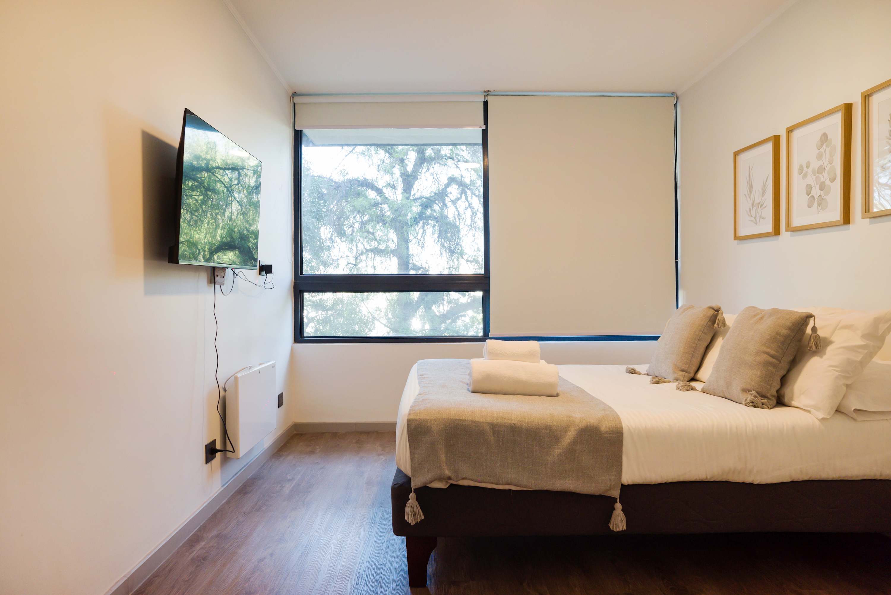 Relax in this cozy bedroom with a serene view and modern amenities, perfect for unwinding after exploring.