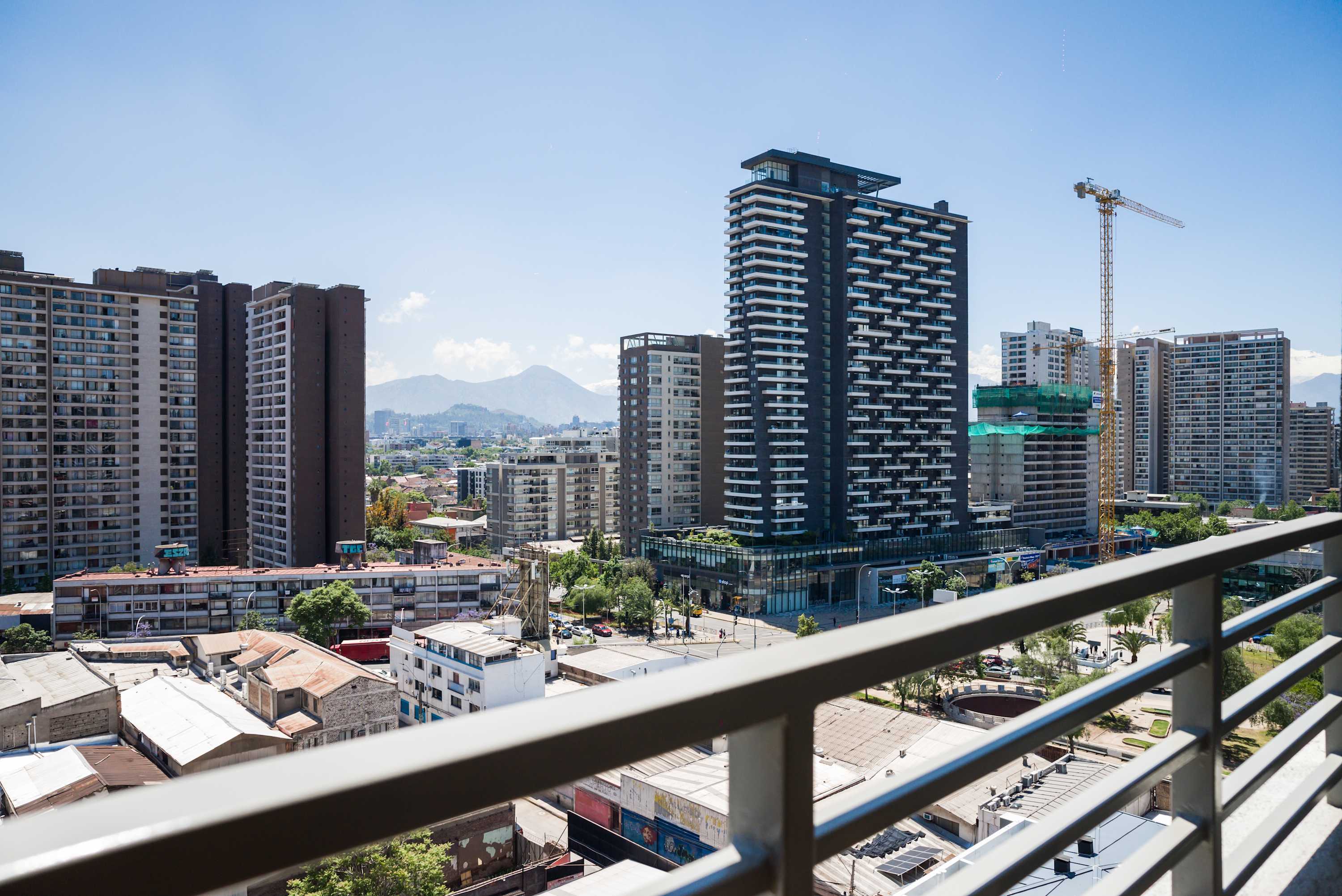 Relax on your private balcony with breathtaking views of Santiago's skyline and distant mountains.