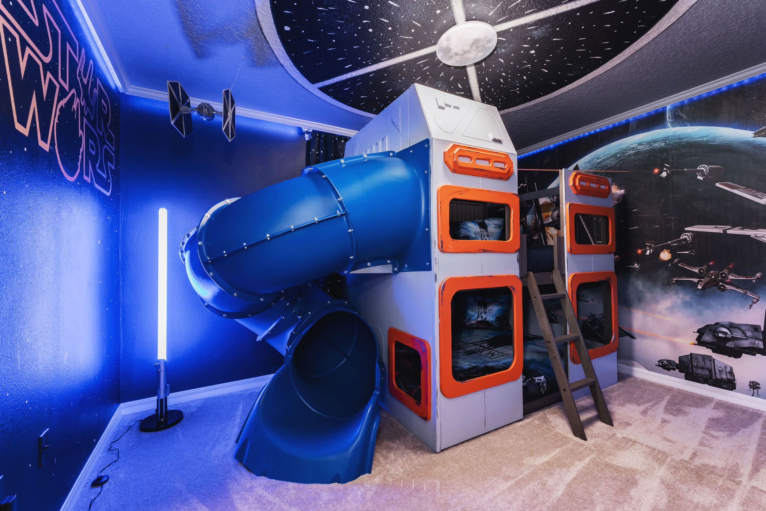 Blast off into adventure in this space-themed room with a slide and bunk beds, perfect for kids and sci-fi fans!