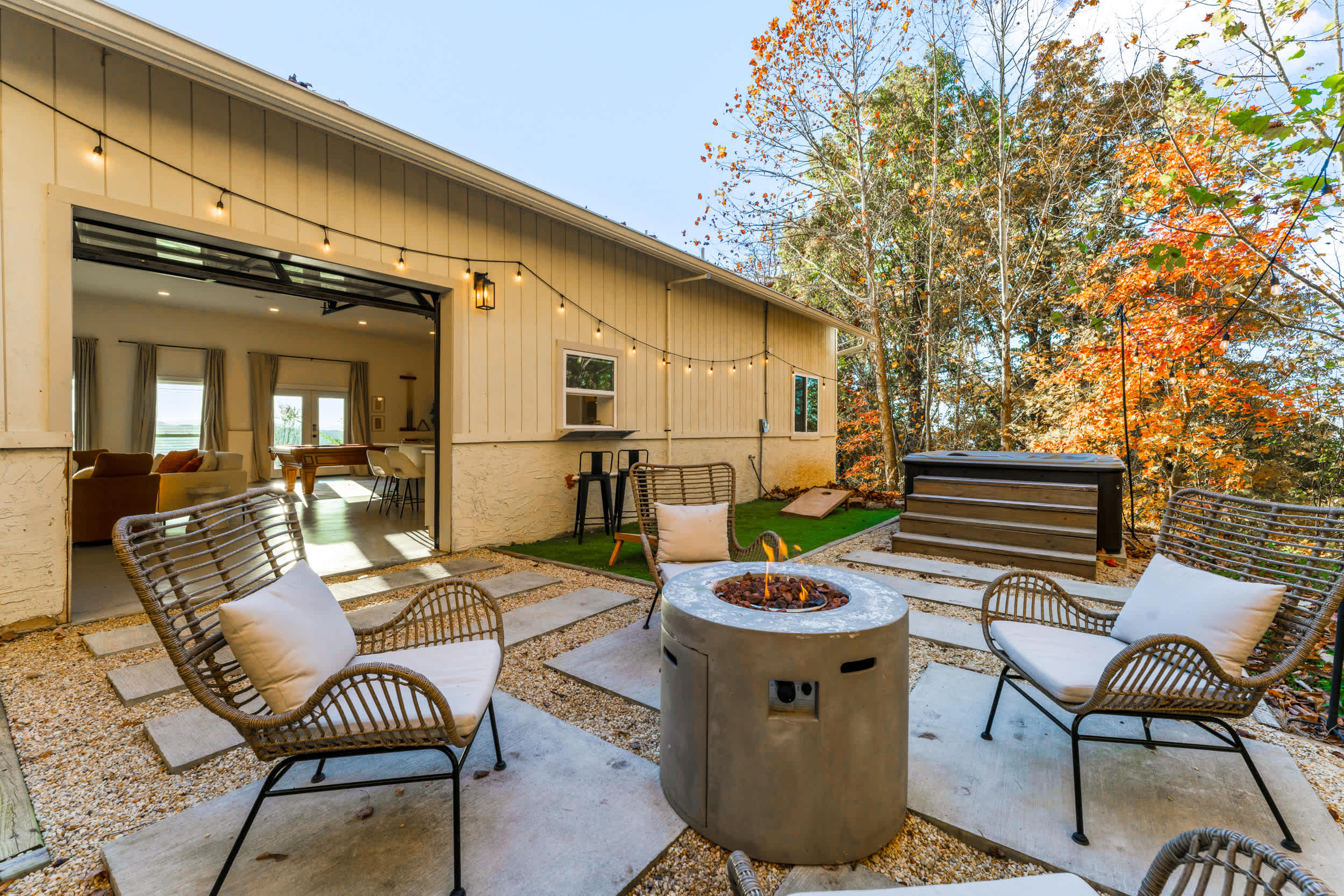 Backyard oasis with firepit, hot tub, bar seating, and cornhole for fun evenings