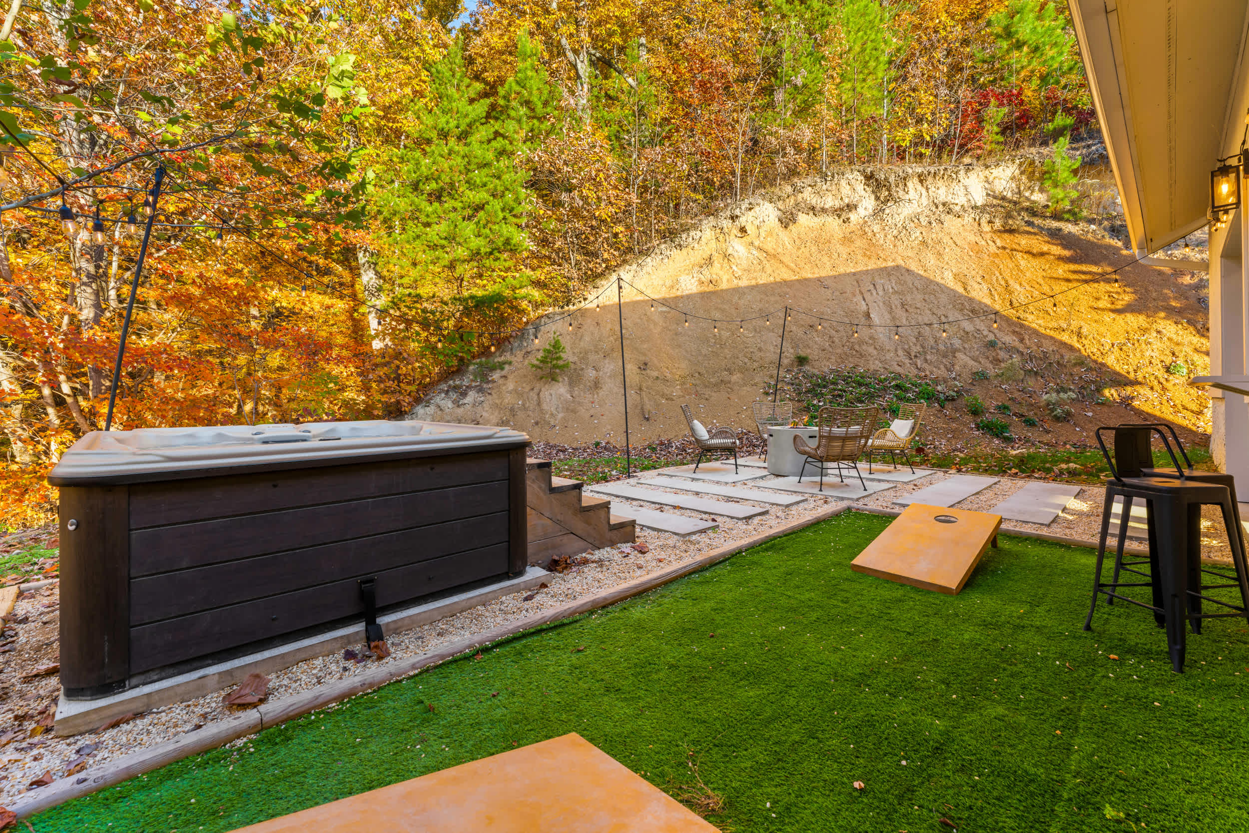 Backyard oasis with firepit, hot tub, bar seating, and cornhole for fun evenings