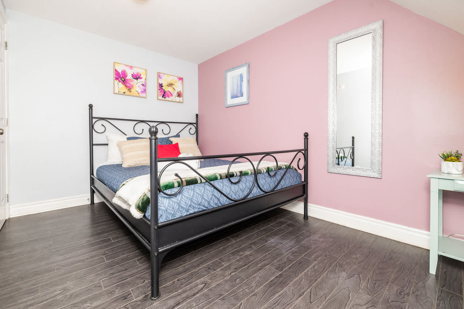 Inviting bedroom with soft pink walls and a comfortable queen bed