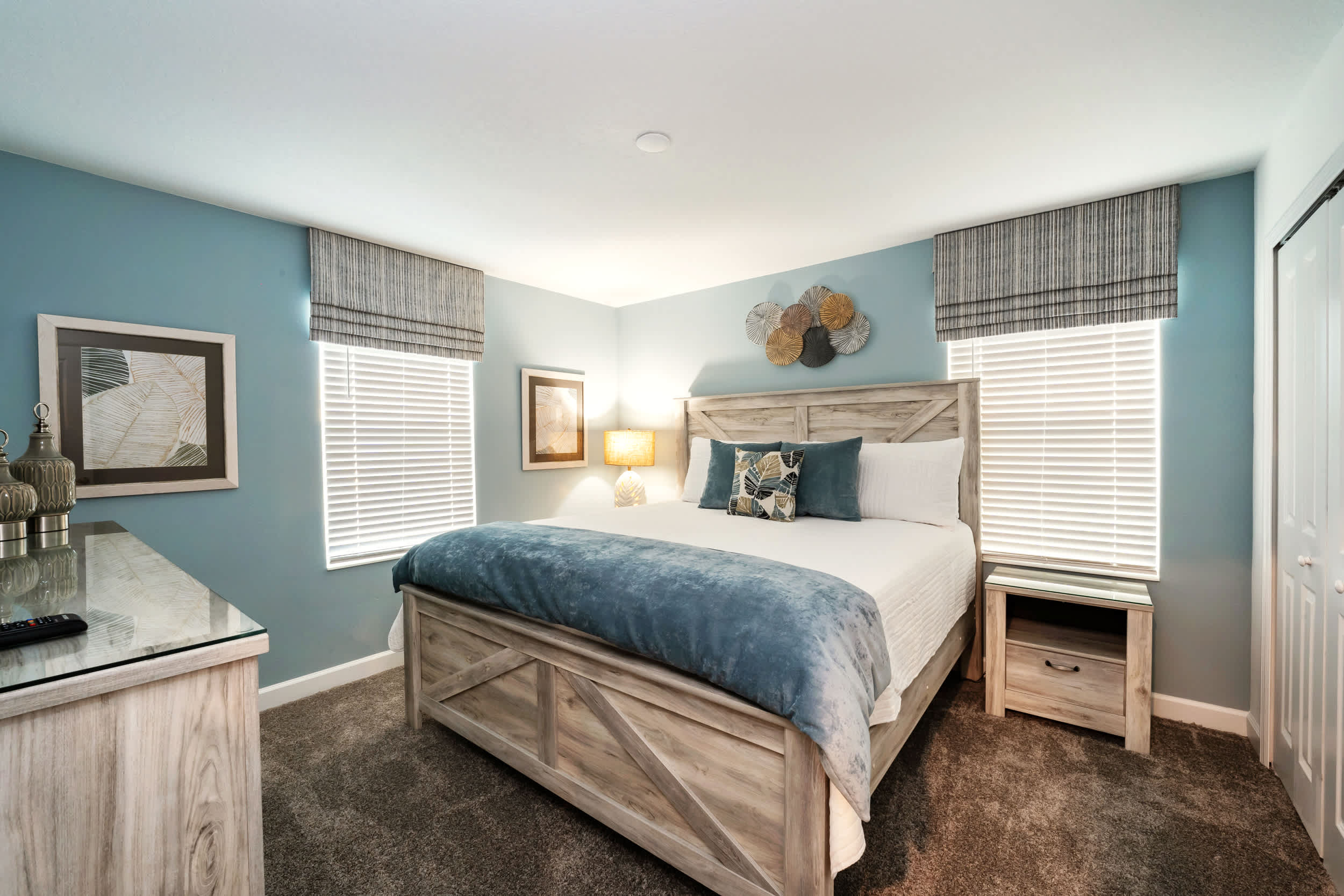 Relax in this serene bedroom with plush bedding and soothing blue hues, perfect for a peaceful night's sleep.