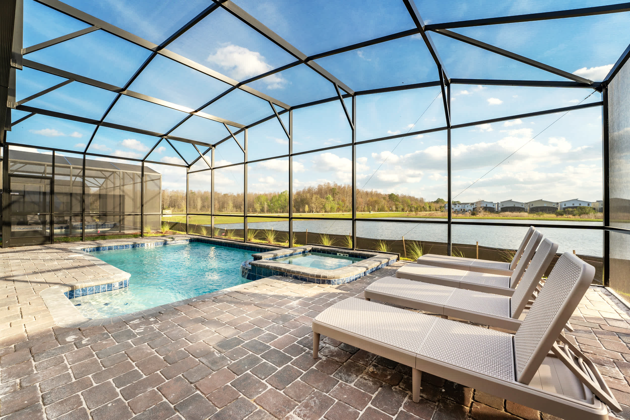 Relax by the private screened-in pool and hot tub with stunning lake views, perfect for unwinding in tranquility.