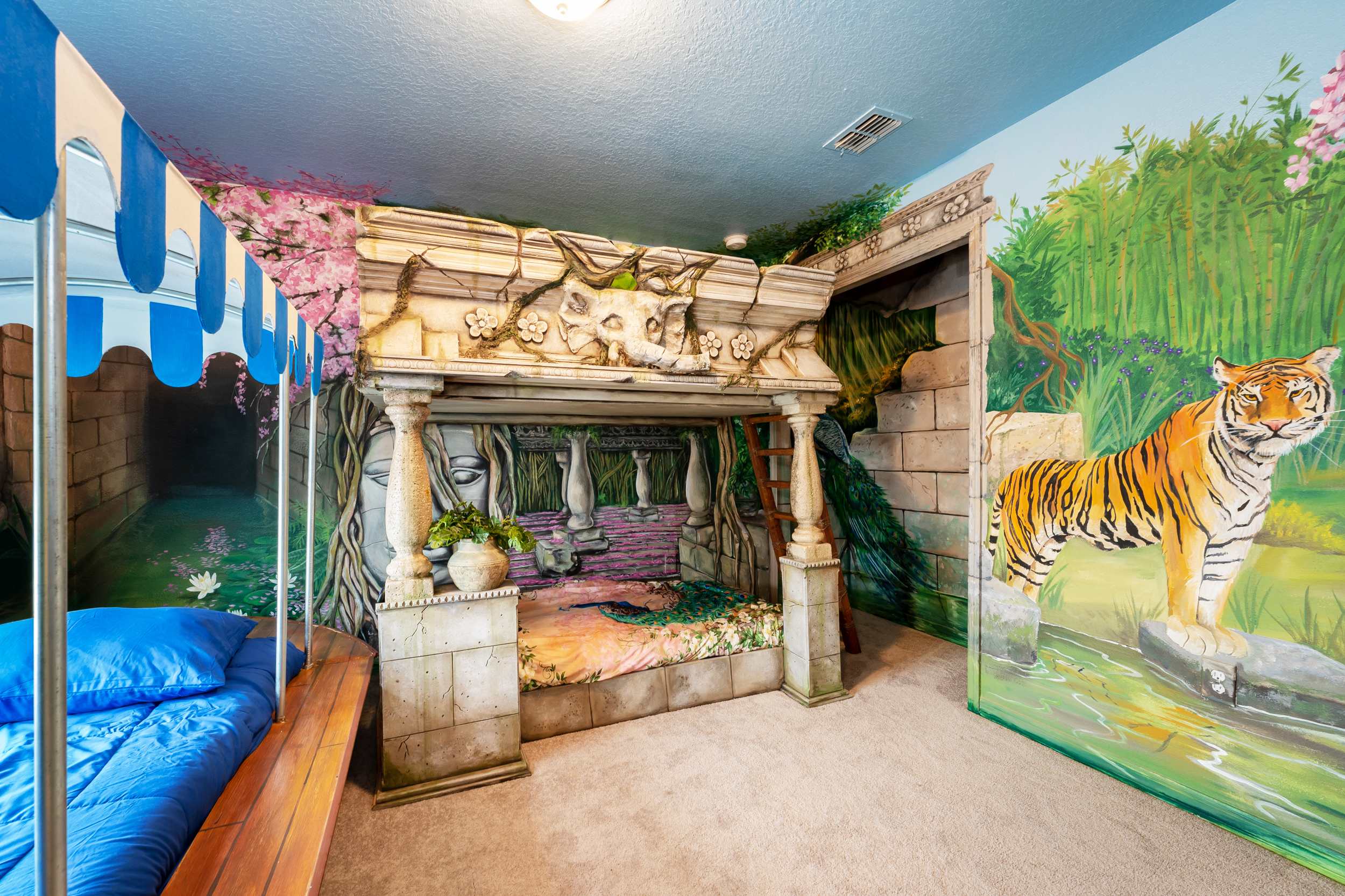 Immerse in a jungle adventure with this themed room featuring vibrant murals and a unique bunk bed design.