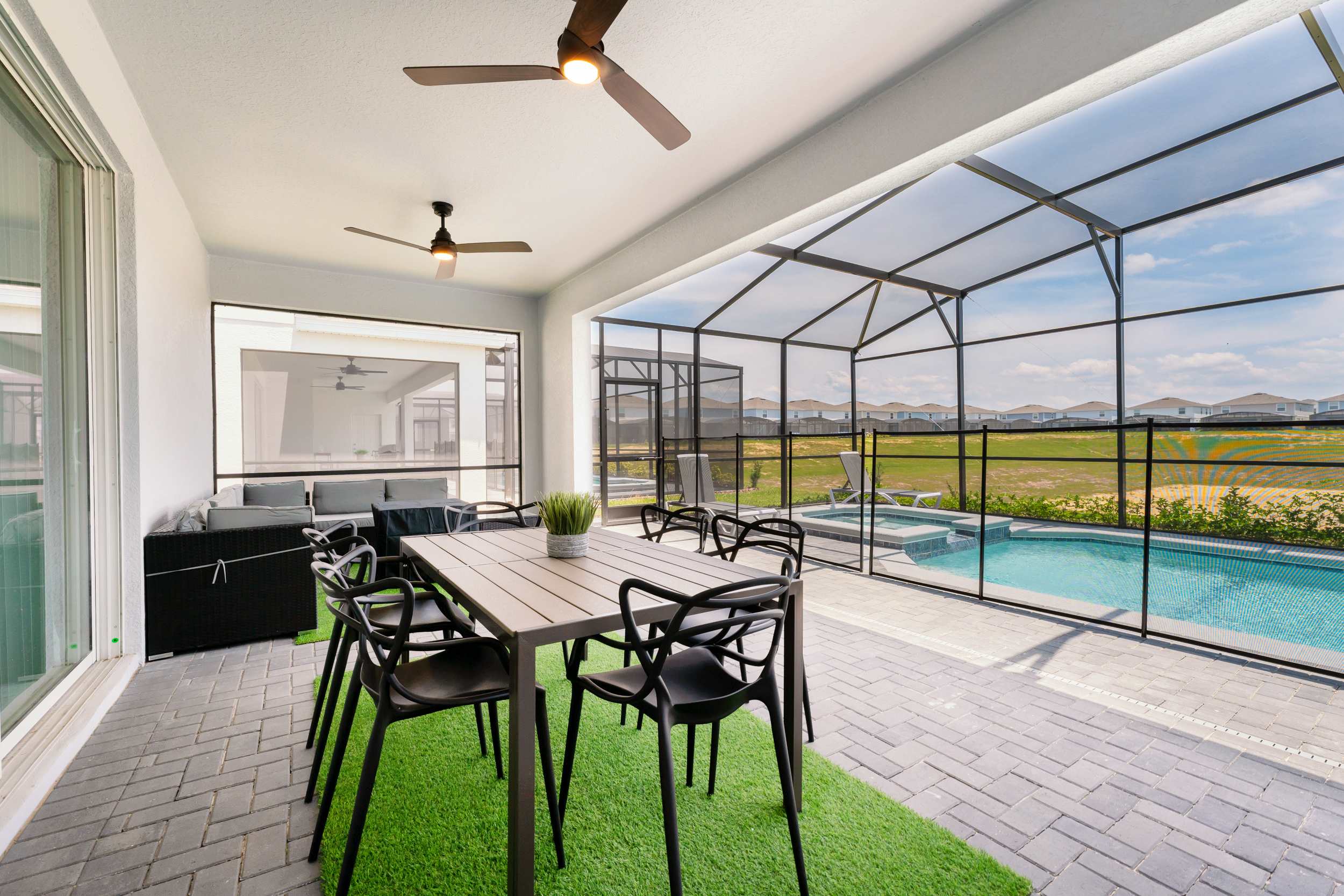 Enjoy al fresco dining on a spacious patio with pool views, perfect for relaxation and gatherings.
