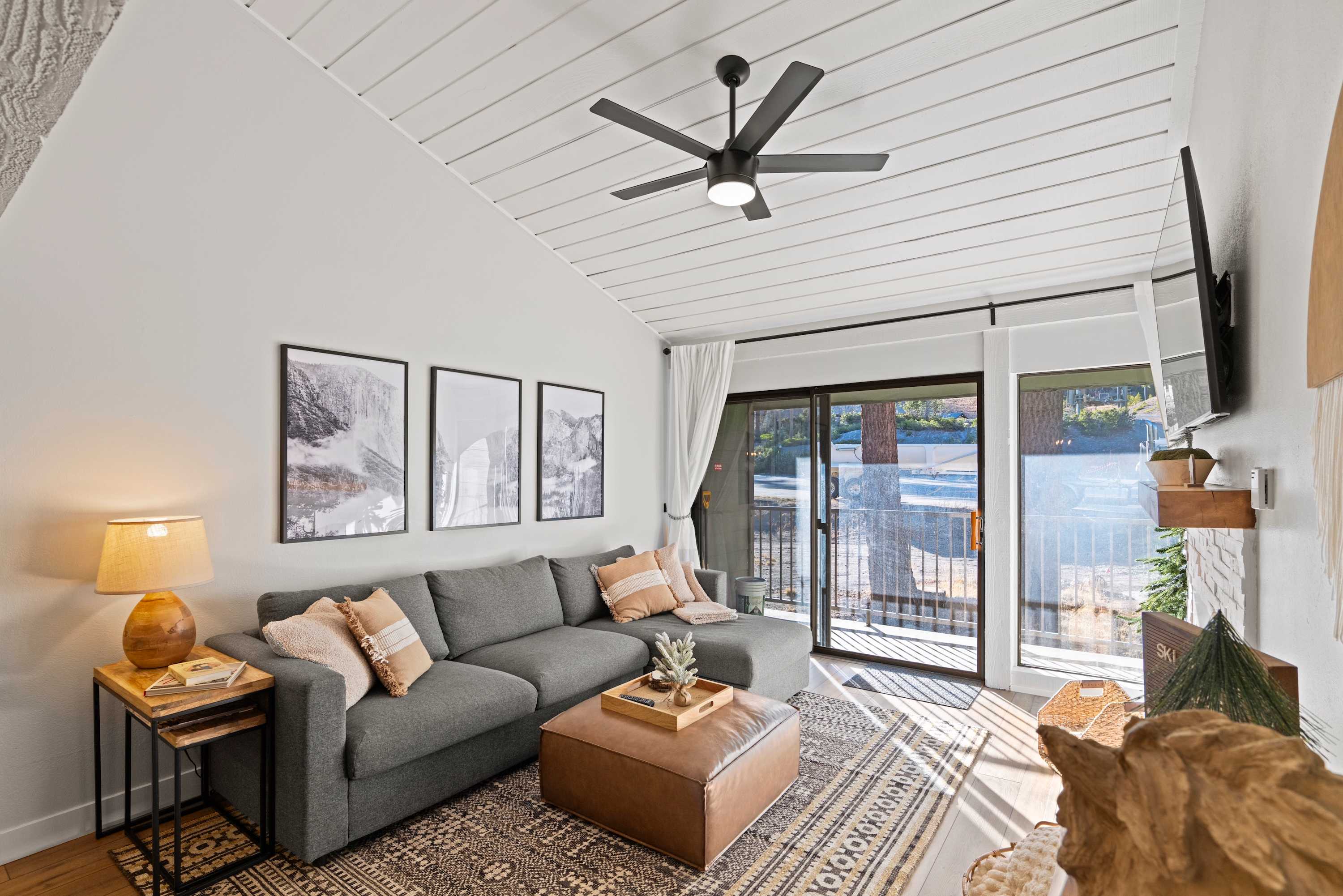 Living room with TV, gas fireplace, balcony access, and sofa sleeper