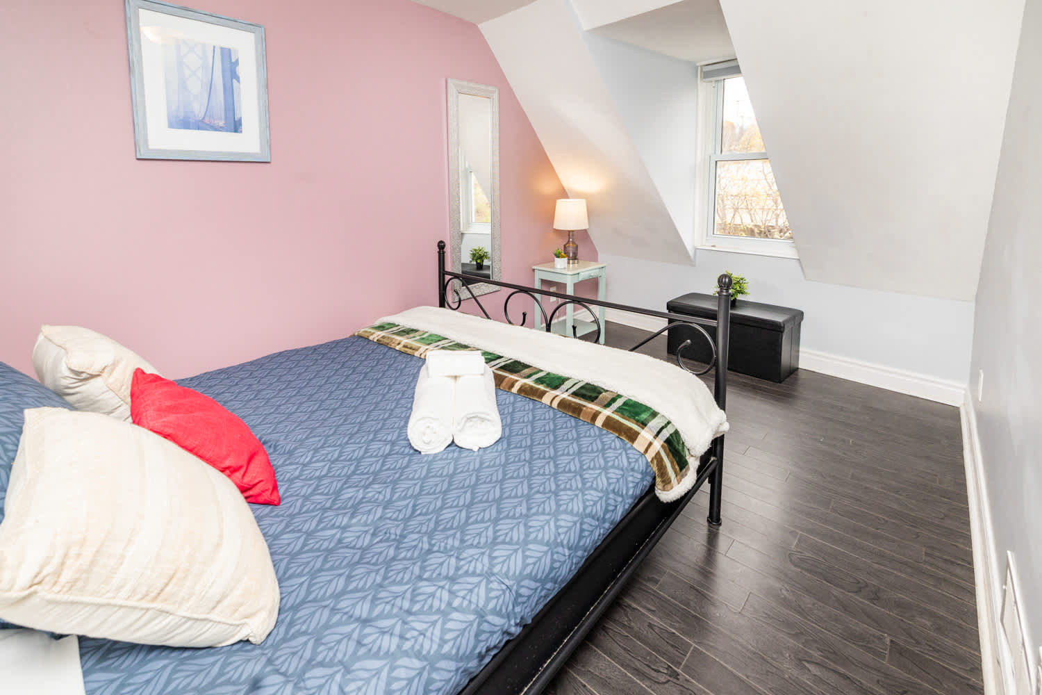 Inviting bedroom with soft pink walls and a comfortable queen bed