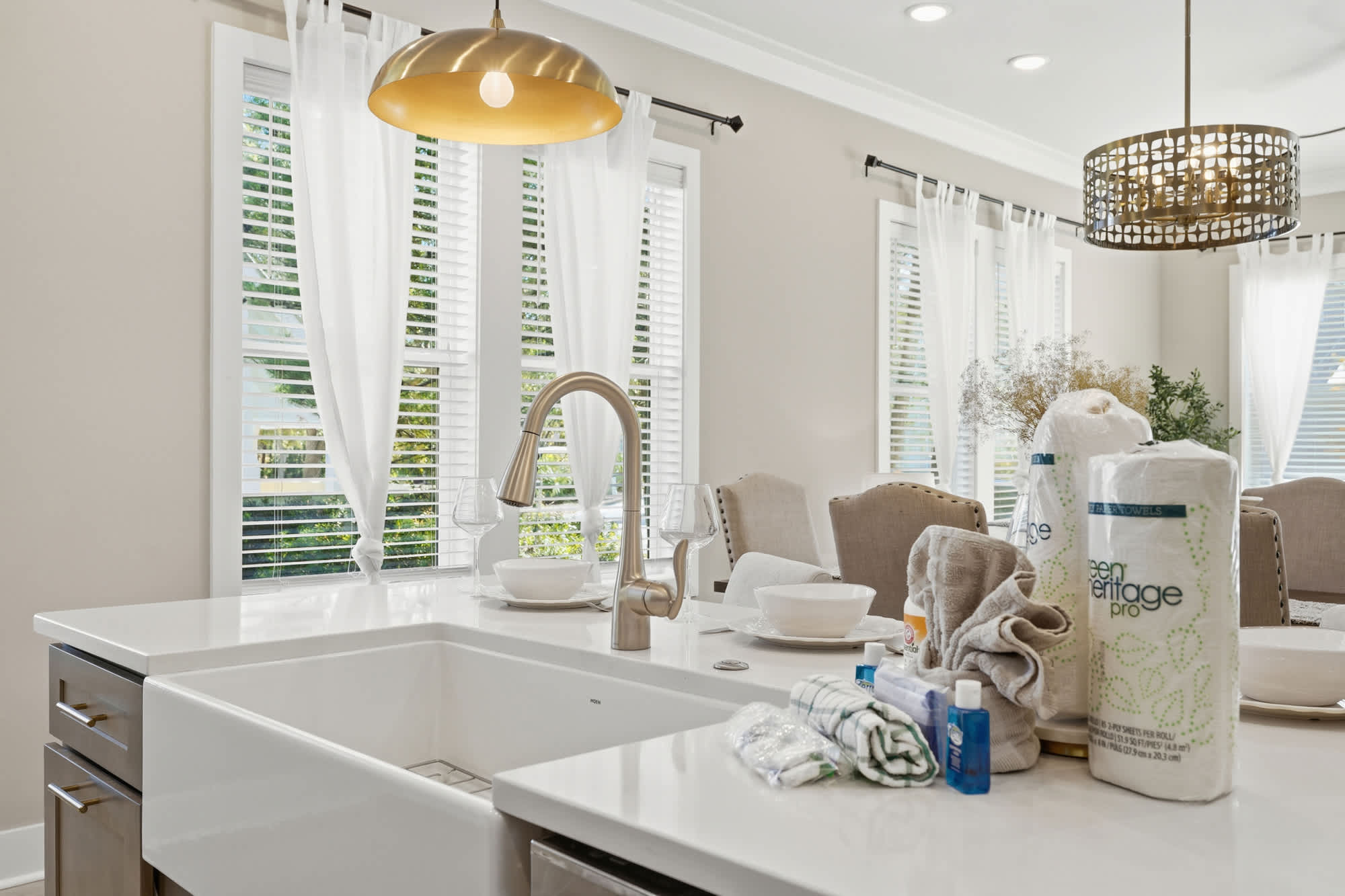 38 W Willow Mist Rd – Bright kitchen with white countertops, sink, dining table set, and large windows with sheer curtains.