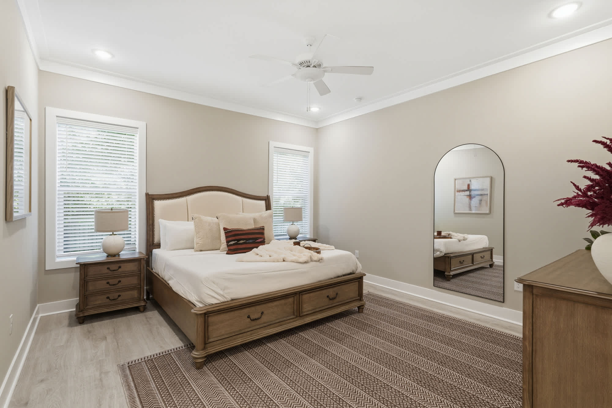 38 W Willow Mist Rd – Bedroom with a large bed, nightstand, mirror, and decorative rug. Natural light from two windows.