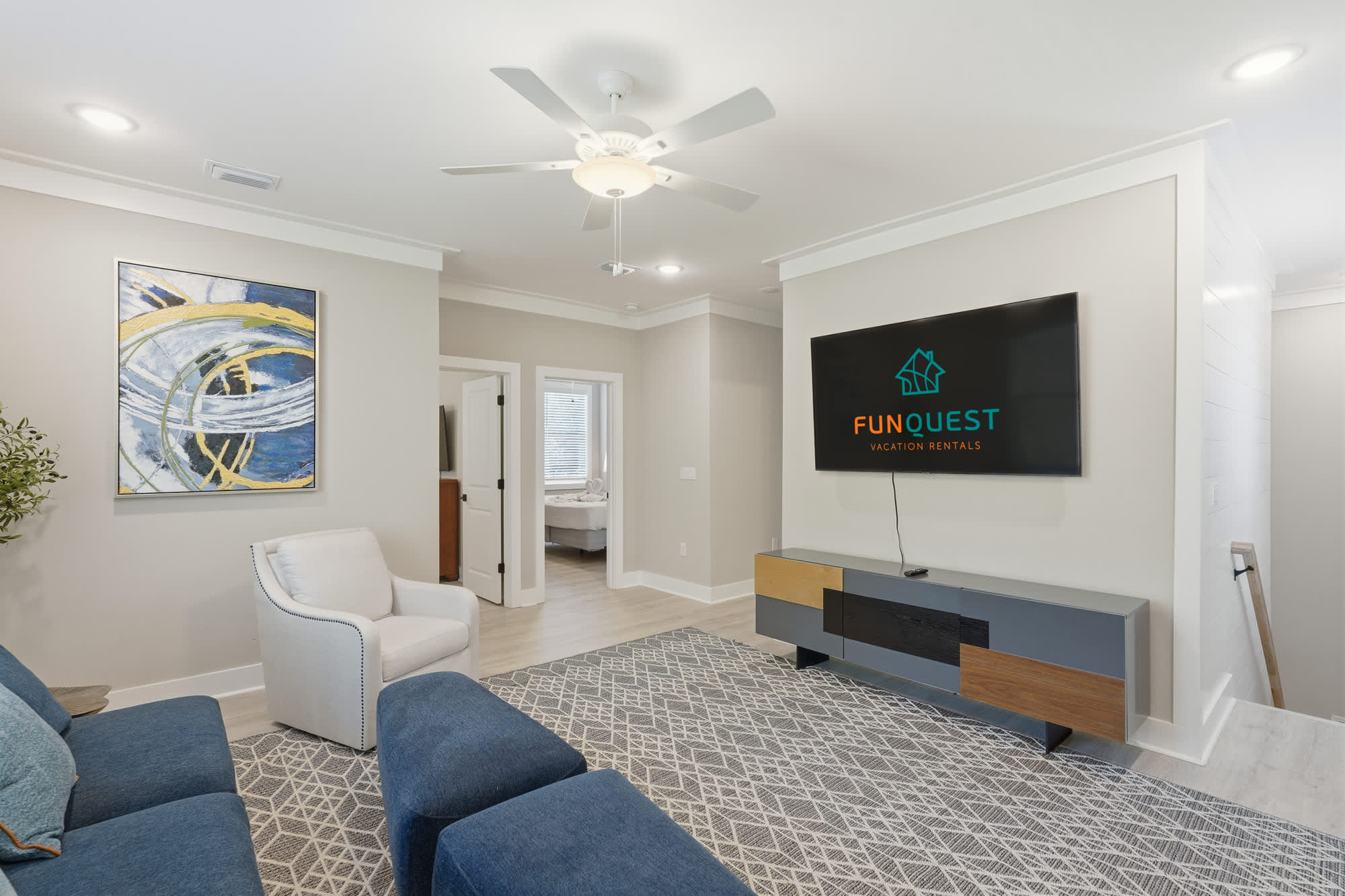 38 W Willow Mist Rd – Cozy living room with blue sofa, white armchair, TV, and decorative artwork.