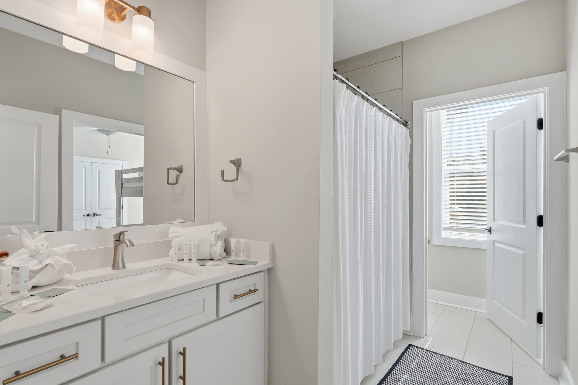 38 W Willow Mist Rd – Bright bathroom with a double sink, mirrors, shower curtain, and window.