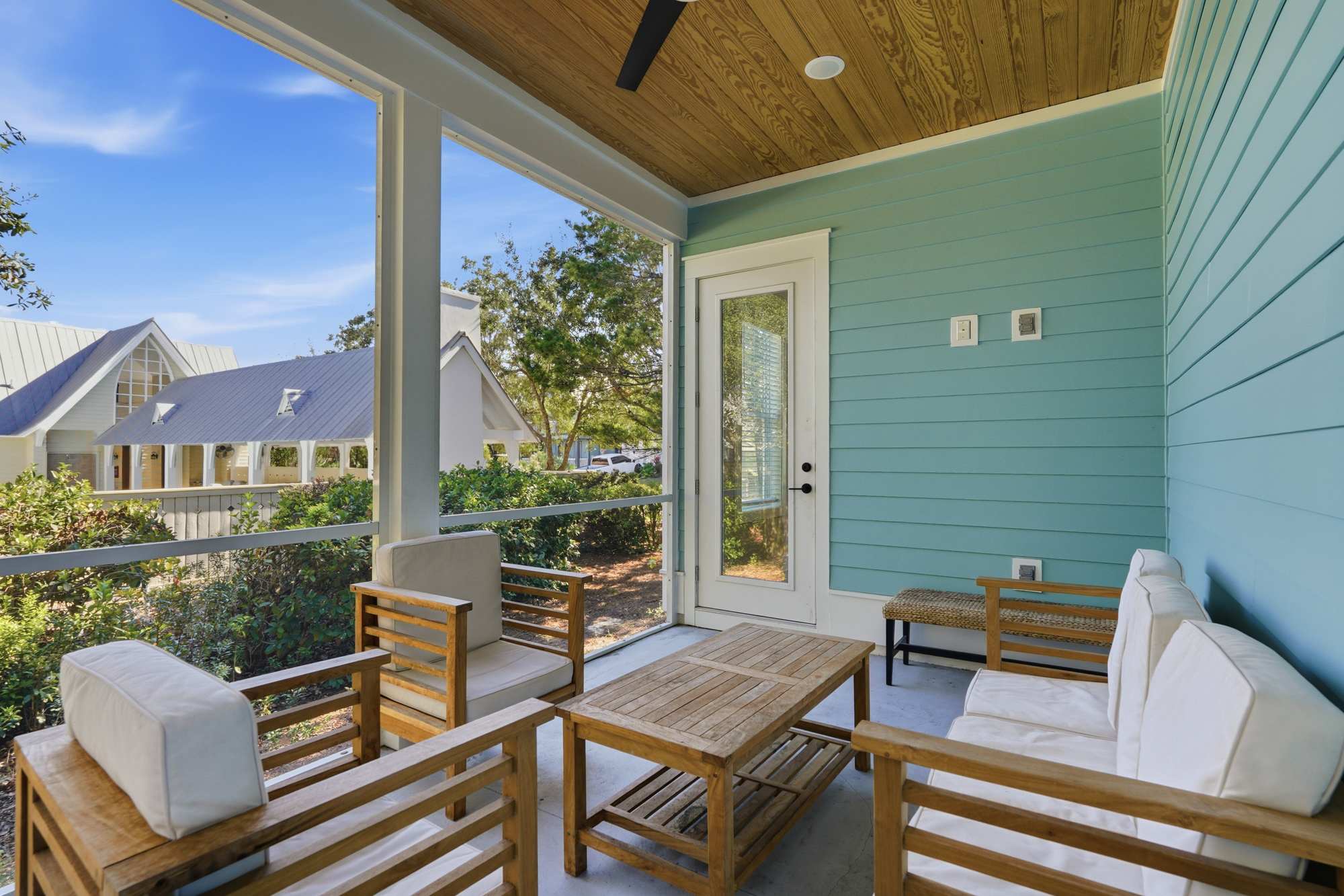 38 W Willow Mist Rd – Covered porch with wooden furniture, small table, and view of nearby building and greenery.