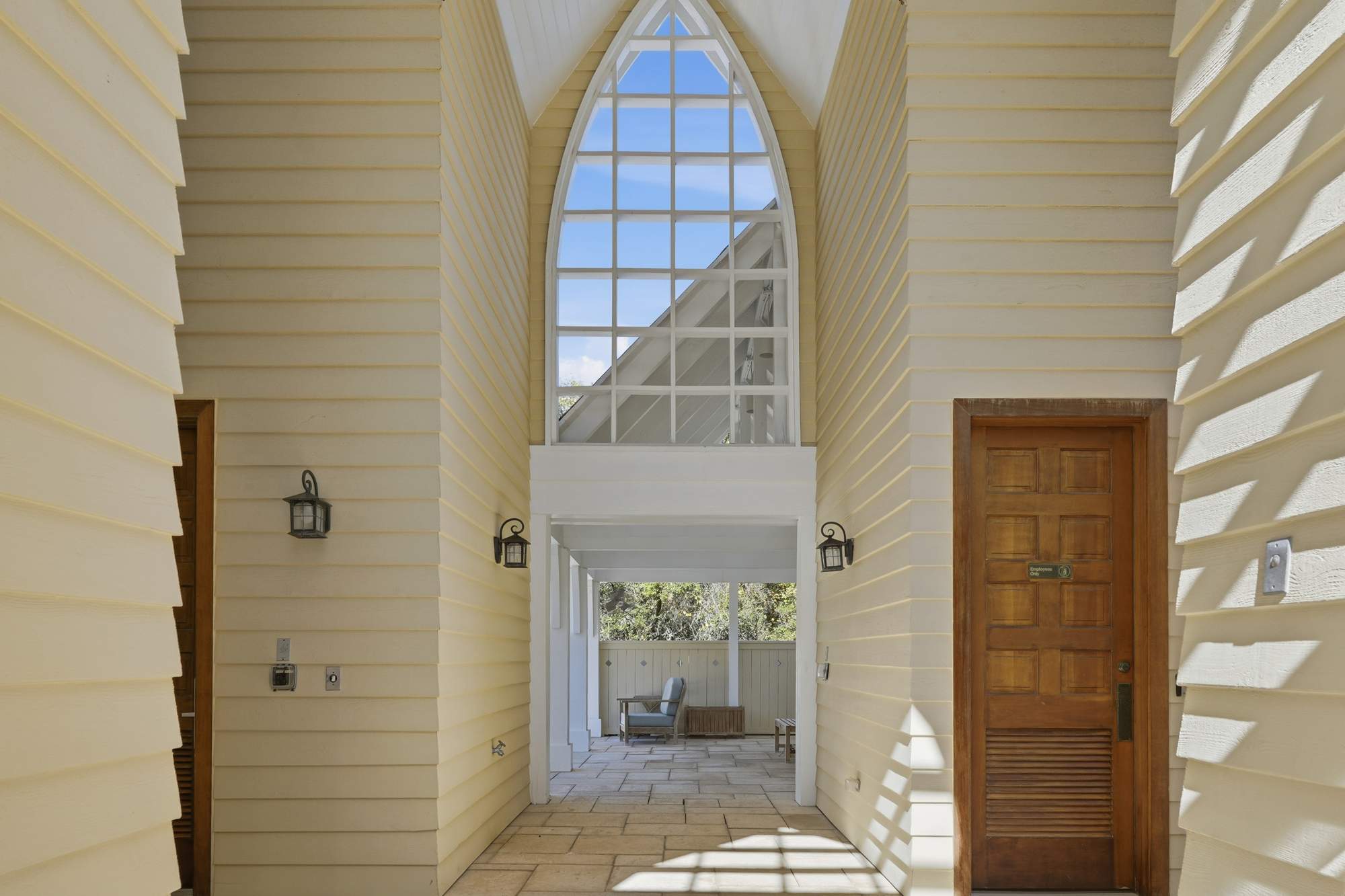 38 W Willow Mist Rd – Hallway leading to an outdoor seating area, featuring high windows and yellow siding.
