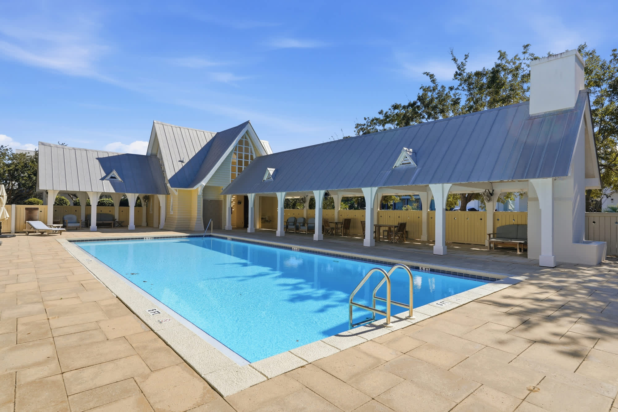 38 W Willow Mist Rd – Swimming pool surrounded by tiled patio, enclosed by a fence, with covered seating areas and blue sky.