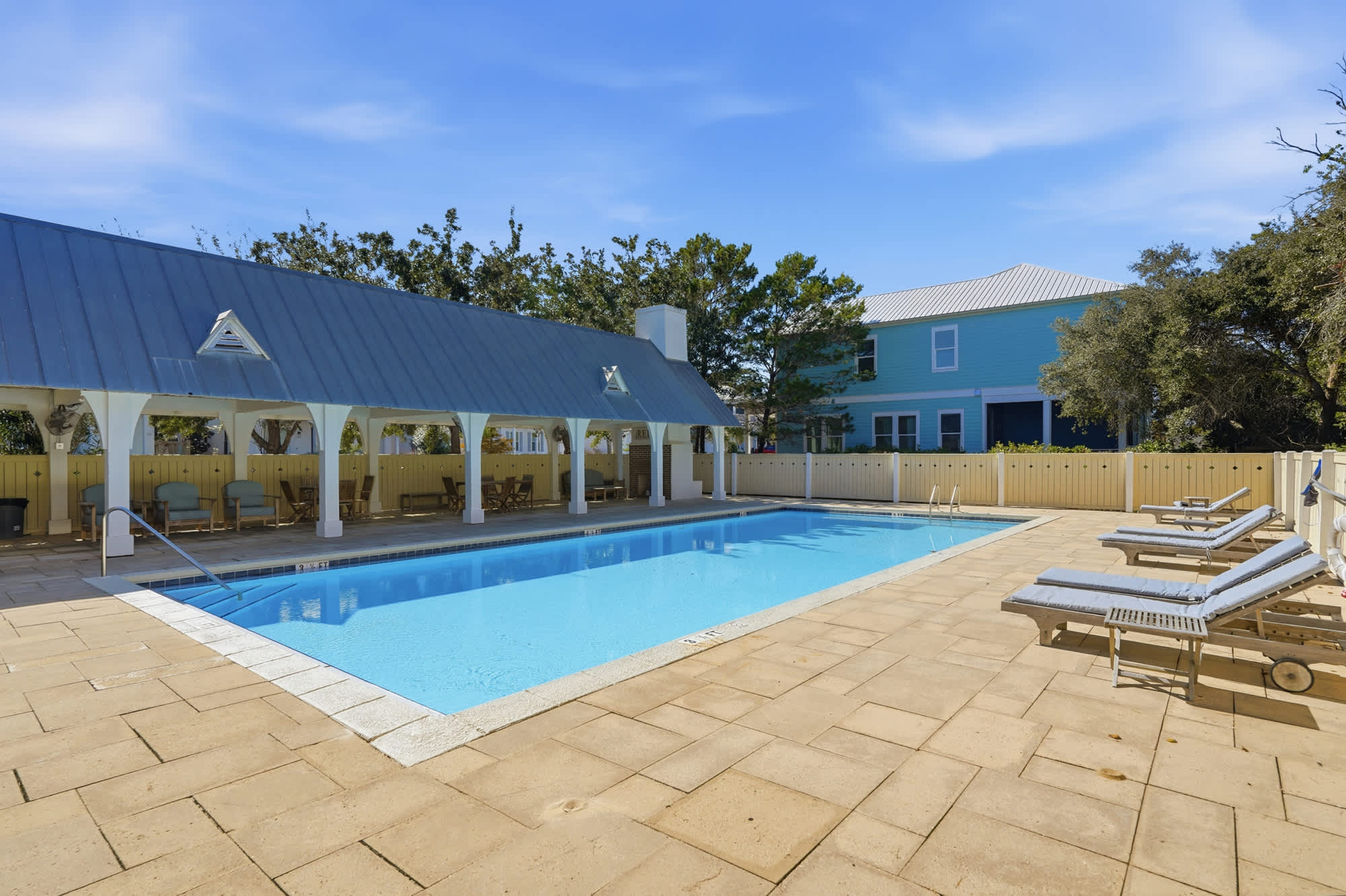 224 W Willow Mist Rd – Swimming pool surrounded by lounge chairs and shaded seating area, with a view of nearby house and greenery.