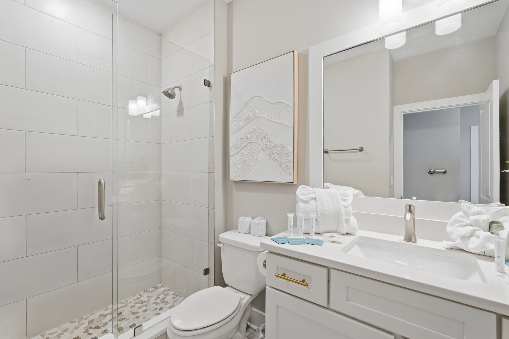 38 W Willow Mist Rd – Bright bathroom with glass shower, modern sink, and decorative wall art.
