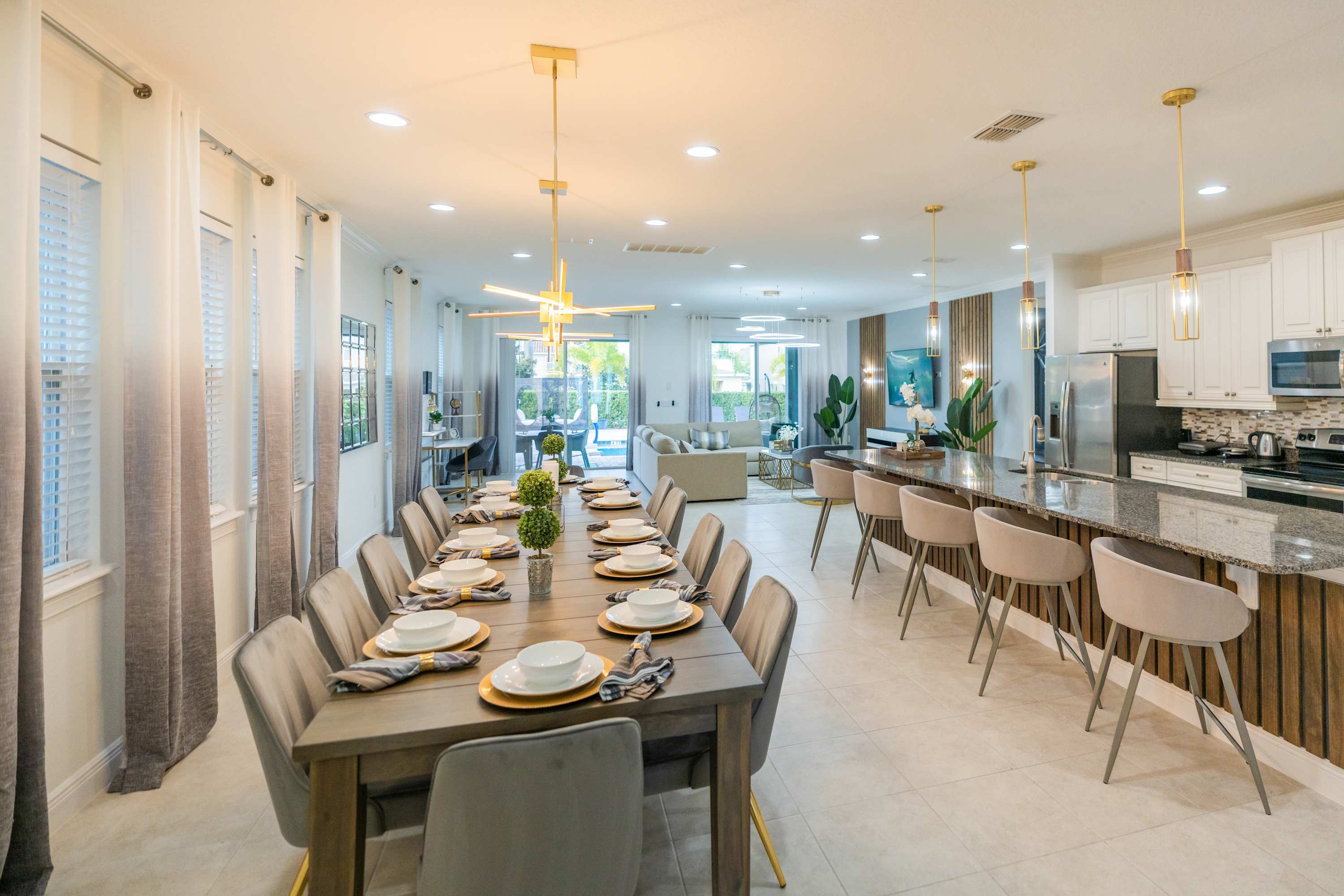 Elegant dining and kitchen area perfect for large gatherings, featuring modern decor and seamless indoor-outdoor flow.