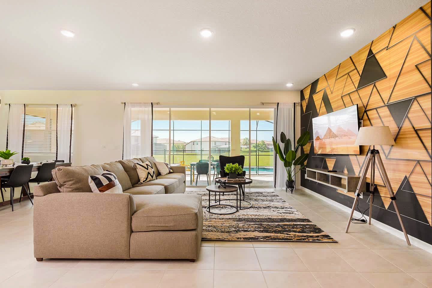 Relax in this stylish living room with a stunning geometric accent wall and pool view, perfect for unwinding after a day of adventure.