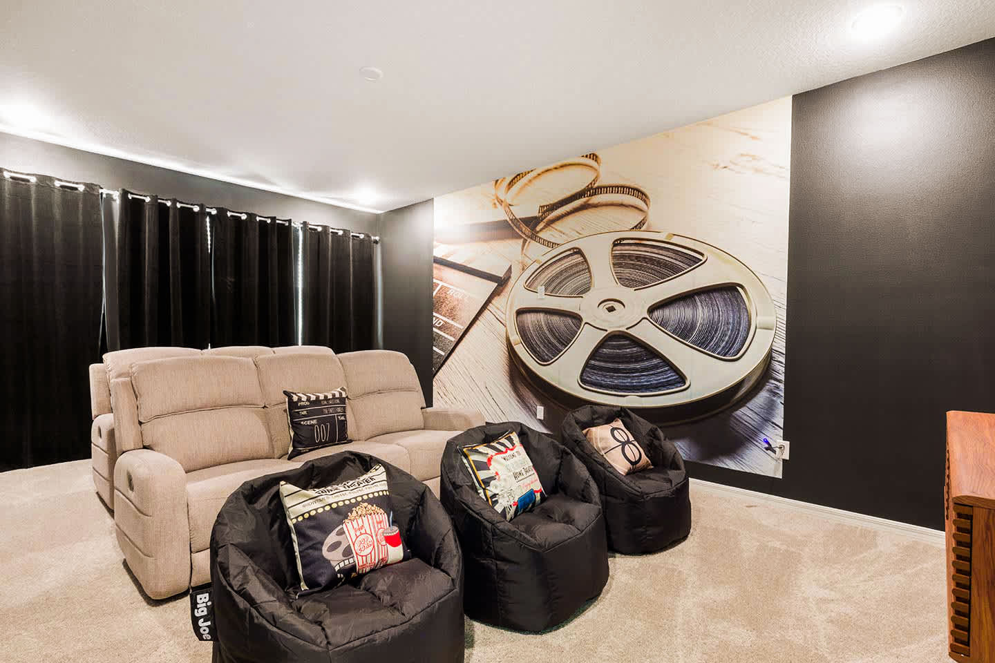 Experience movie nights in style with this cozy home theater, featuring plush seating and a cinematic mural for an immersive experience.