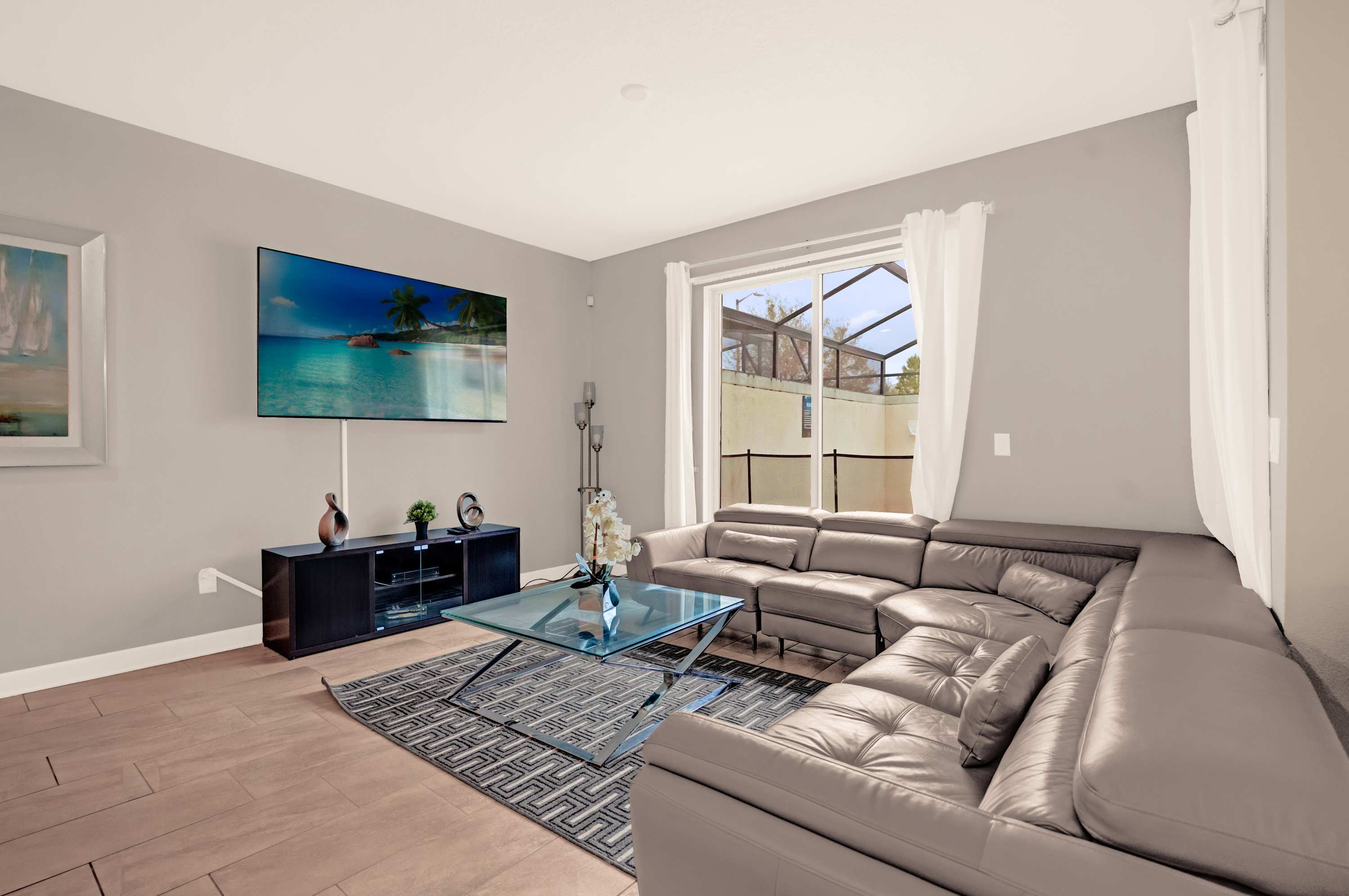 Relax in this spacious living room with a plush sectional sofa and enjoy entertainment on the large flat-screen TV.