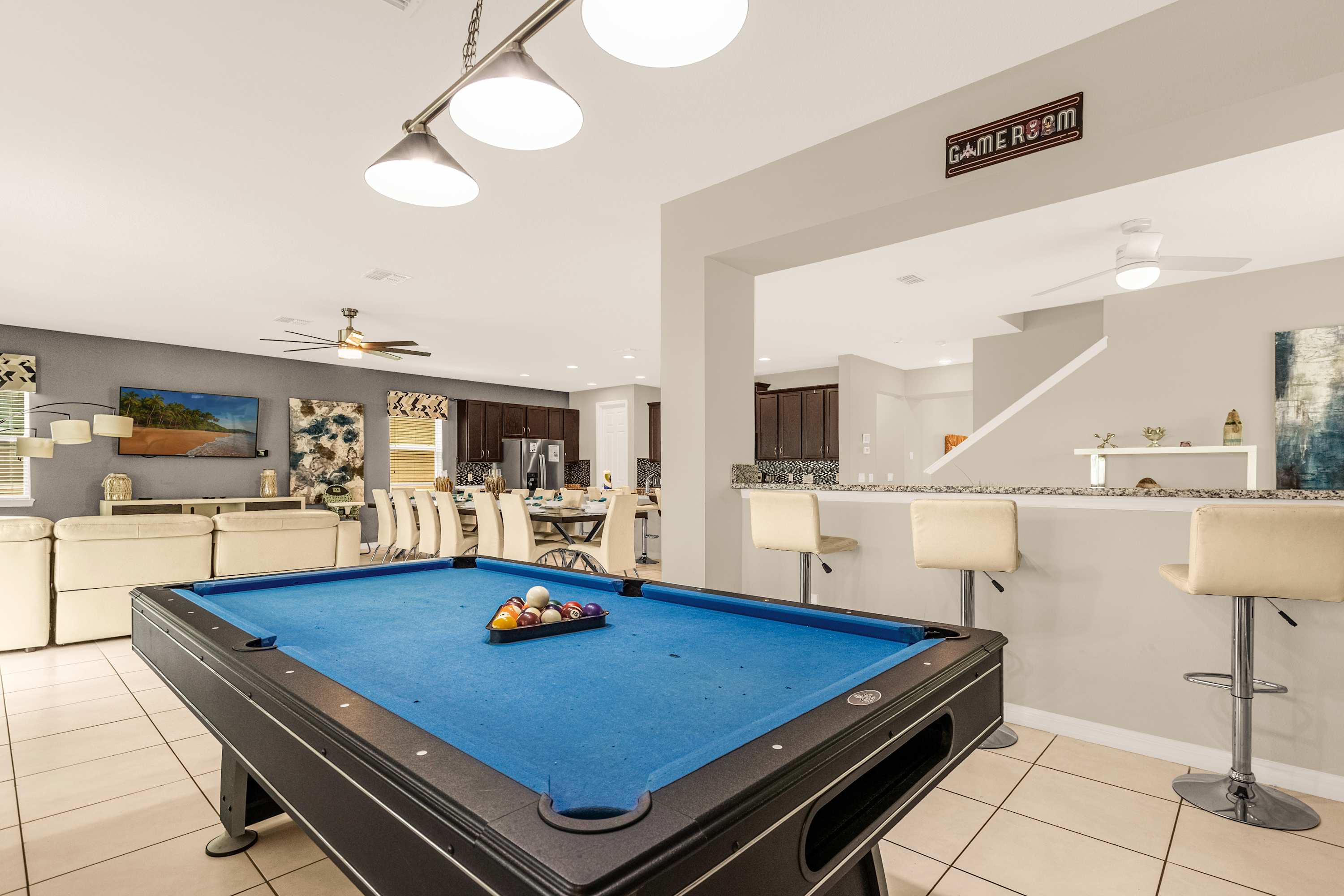 Enjoy endless fun in this stylish game room with a pool table, cozy seating, and a large dining area perfect for gatherings.