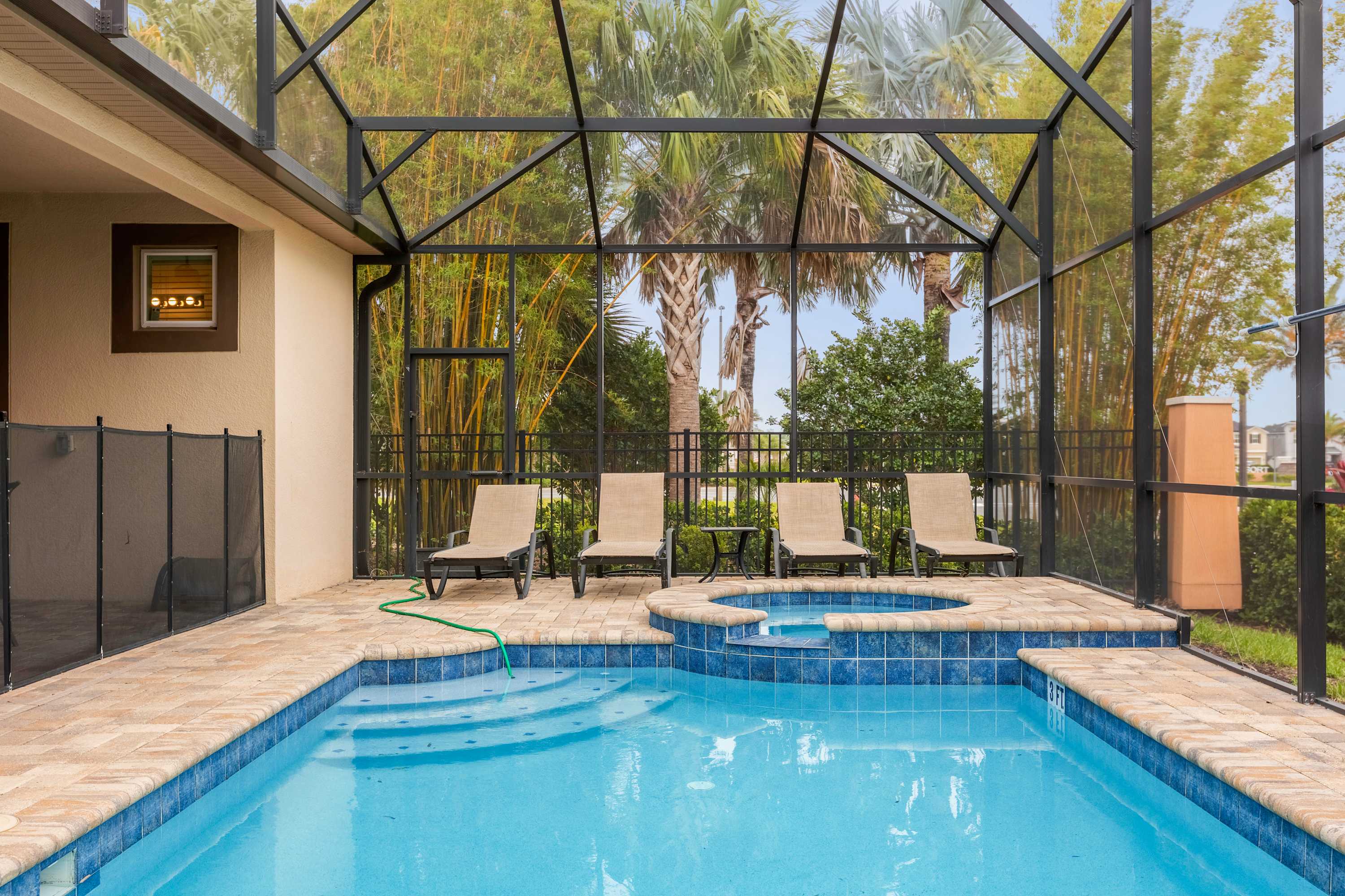 Relax by your private pool and hot tub oasis, surrounded by lush greenery and comfortable loungers.